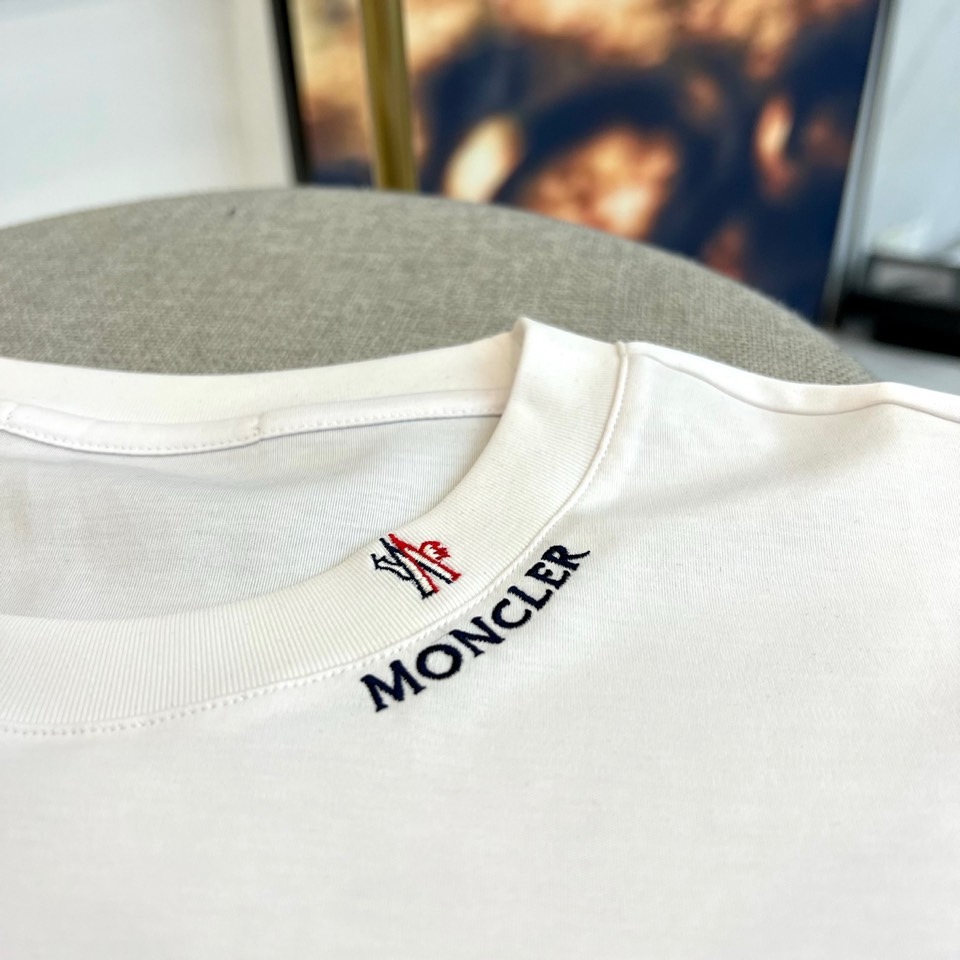 Mon蒙口、2026春夏新品短袖T恤，以纯色为基底，诠释极简主义美学。领子上精致字母标识点缀，低调彰显品