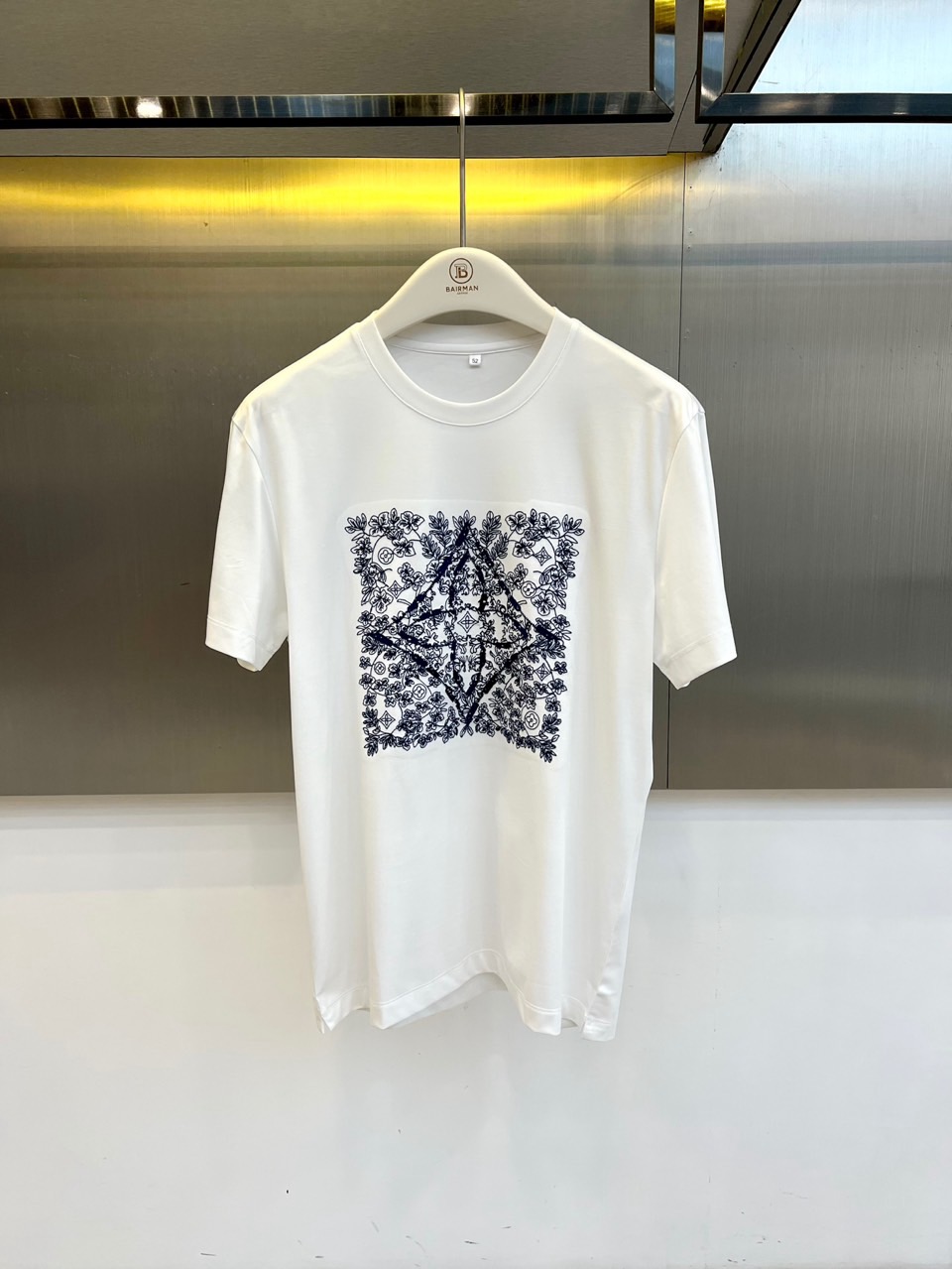 1v威登、2026春夏新品短袖T恤，以纯色为基底，胸前方形繁花图案成为视觉焦点，复古花卉与几何线条交织缠