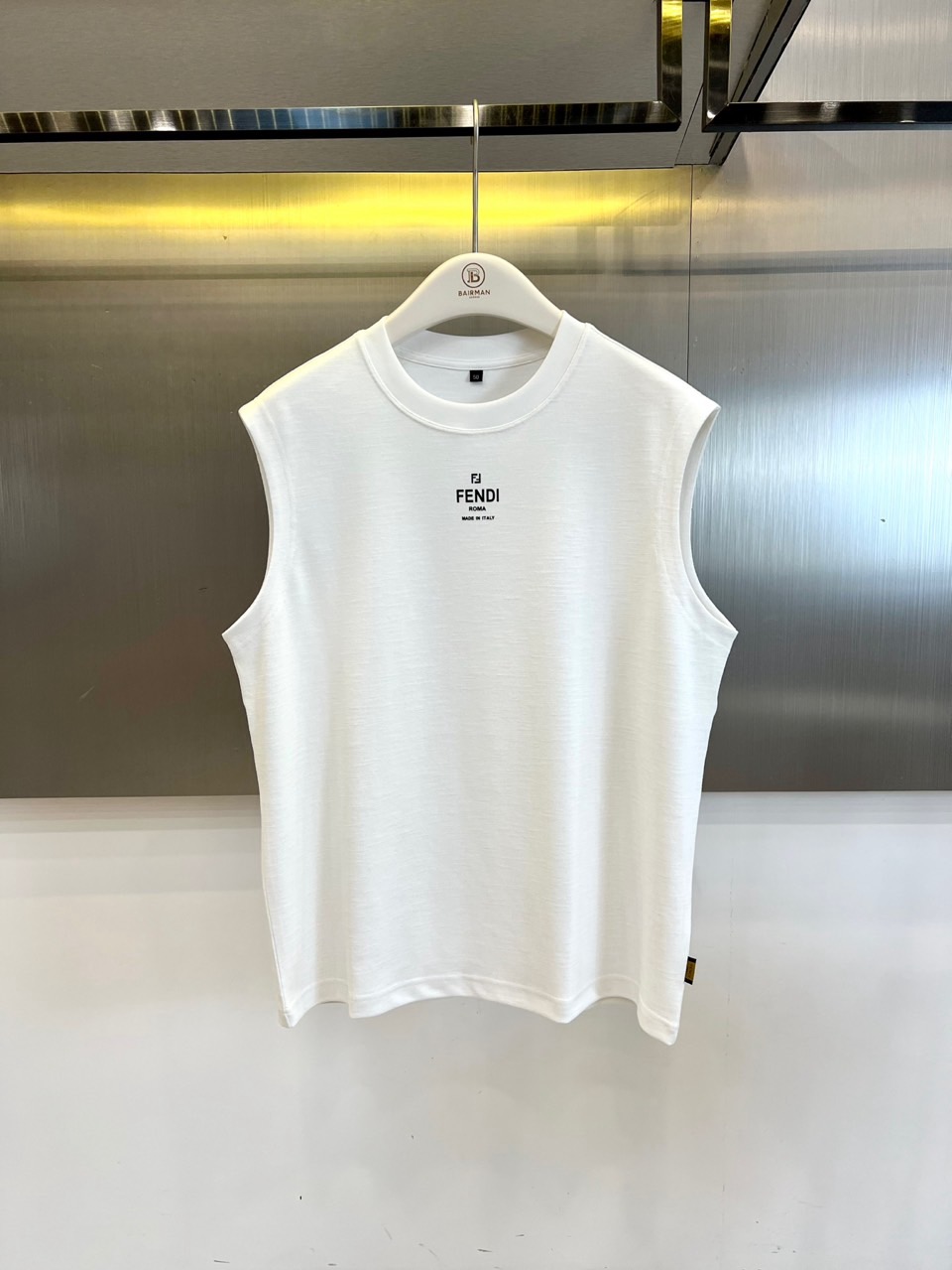 NO:830803,Fend Fendi, 2026 spring and summer new vest T-shirt, reconstructs the light luxury sports style with a minimalist silhouette. The round neck sleeveless tailoring is neat and stylish, accurately fitting the shoulder line, releasing the refreshing freedom in summer. The classic words on the chest are low-key, highlighting the brand genes and Italian ingenuity, unobtrusive but with a high-end aura. The fabric is made of 46 polyester fiber + 34.9 cotton + 14  .6 ramie + 4.5 spandex blend, light and breathable with a slightly elastic fit. Ramie fiber gives natural texture and coolness, cotton ensures skin-friendly comfort, and spandex increases freedom of movement. It is suitable for commuting, leisure, light sports and other scenes. The version is loose and not procrastinating, and the hem hangs naturally, modifying the body shape while retaining the sense of breathing. Class B safety category complies with GB  18401-2010 standard, daily wear with peace of mind. The 2026 spring and summer series continues FENDI's ultimate pursuit of materials and craftsmanship, cleverly blending urban modernity and lazy vacation style. It is an indispensable and versatile item in the wardrobe - it can be worn alone to show your personality.  It can also be layered to create layers, easily control the fashion rhythm from morning to night, and bring a sense of luxury and calmness to every appearance. 48-56 (model weighs 173,143 pounds, upper body size 50),, fendi, fendi, tees, t-shirt,19860909Fend芬迪、2026春夏新品背心T恤,以极简廓形重构轻奢运动风,圆领无袖剪裁利落有型,精准贴合肩线,释放夏日清爽自由.胸前经典字样低调点睛,彰显品牌基因与意式匠心,不张扬却自带高级气场.面料采用46聚酯纤维+34.9棉+14.6苎麻+4.5氨纶混纺,轻盈透气又具微弹贴合感,苎麻纤维赋予天然肌理与凉感,棉质保证亲肤舒适,氨纶提升活动自由度,适合通勤、休闲、轻运动等多场景切换.版型宽松不拖沓,下摆自然垂坠,修饰身形同时保留呼吸感,B类安全类别符合GB 18401-2010标准,日常贴身穿着安心无忧.2026春夏系列延续FENDI对材质与工艺的极致追求,将都市摩登与慵懒度假风巧妙融合,是衣橱中不可或缺的百搭单品——可单穿彰显个性,亦可叠穿打造层次,轻松驾驭从早到晚的时尚节奏,让每一次出场都自带高级感与从容气度.48-56（模特173,143斤上身50码）,,fendi,fendi,tees，t-shirt,,Men's clothing
