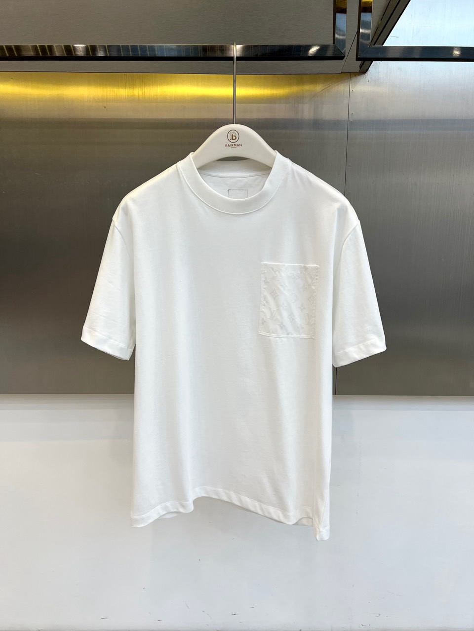 NO:830835,1v Louis Vuitton, 2026 spring and summer new T-shirt, presented with a classic round neck and simple short-sleeved silhouette. The square pocket on the left chest is decorated with the brand's iconic texture pattern, embellished with a combination of 'B' and 'BAIHAN' logos, highlighting its low-key luxury identity with exquisite craftsmanship. The overall design integrates the exquisite aesthetics of high fashion houses into daily items, in minimalist lines  Extraordinary details are hidden. The style is both casual and urban. Whether worn alone with casual trousers, or layered with a suit jacket, it can easily enhance the look and texture, calmly control a variety of occasions, and interpret the simple and luxurious attitude that is indispensable in a modern wardrobe. 48-56 (model is 173, 143 pounds, upper body size 50),, louis  vuitton,jackets & coats,T-shirt,tees,t-shirt,business suit,198609091v路易威登、2026春夏新品T恤,以经典圆领与简约短袖廓形呈现.左胸方形口袋饰有品牌标志性纹理图案,点缀“B”与“BAIHAN”标识组合,以精湛工艺凸显低调奢华身份.整体设计将高级时装屋的精致美学融入日常单品,在极简线条中暗藏非凡细节.风格兼具随性休闲与都市格调,无论是单穿搭配休闲裤装,或作为内搭叠穿西装外套,皆能轻松提升造型质感,从容驾驭多种场合,诠释摩登衣橱中不可或缺的简约奢华态度.48-56（模特173,143斤上身50码）,,louis vuitton,jackets & coats,T-shirt,tees，t-shirt,business suit,,Men's clothing