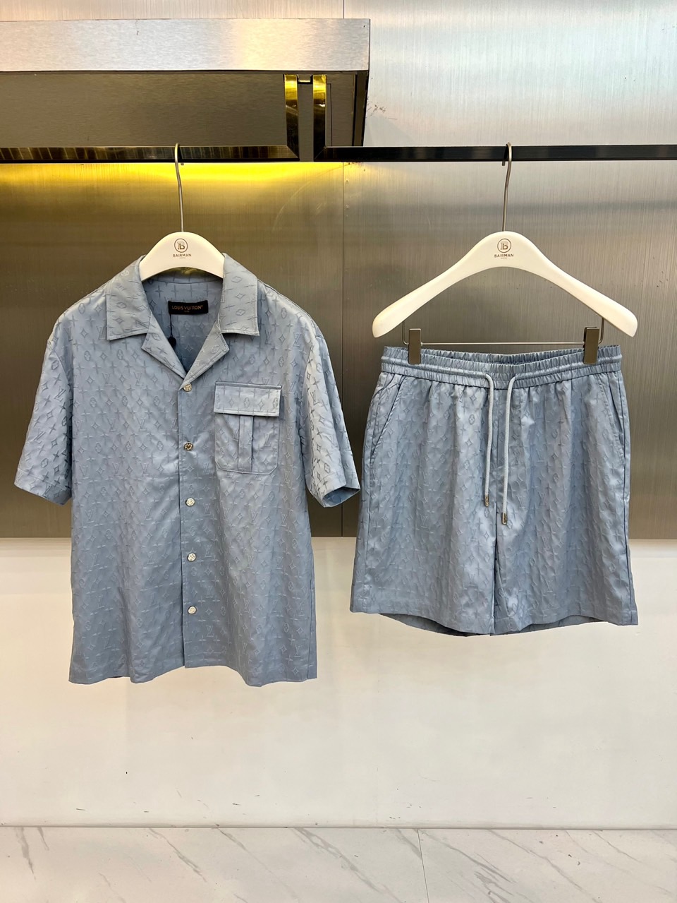NO:840827,One set.  1v Vuitton, 2026 spring and summer new presbyopic suit, reshapes the classic Monogram pattern with pure colors, highlighting the luxurious texture in a low-key manner. The short-sleeved shirt adopts a Cuban collar design, with chest flap pockets, neat and crisp lines, and button opening and closing are simple and elegant; the shorts of the same color use elastic waistbands and drawstrings, the version is loose and comfortable, taking into account both leisure and sports styles. The overall suit uses jacquard technology, and the presbyopic elements are presented under the light and shadow  Delicate texture, full of high-end feel. The fabric is light and breathable, suitable for spring and summer wear, whether it is urban commuting, weekend travel or vacation travel, you can easily control it. The same color combination saves you the trouble of dressing, and a set of upper body instantly shows an elegant and casual high-end atmosphere. It is a must-have texture choice for the wardrobe. 48-56 (model is 173,143 pounds, upper body size 50),, shorts, shirts, T-shirt,19860909一套. 1v威登、2026春夏新品老花套装,以纯色调重塑经典Monogram图案,低调中彰显奢华质感.短袖衬衫采用古巴领设计,搭配胸前翻盖口袋,线条利落挺括,纽扣开合简约大气；同色系短裤选用松紧腰头配抽绳,版型宽松舒适,兼顾休闲与运动风格.整体套装运用提花工艺,老花元素在光影下呈现细腻纹理,高级感十足.面料轻薄透气,适合春夏穿着,无论是都市通勤、周末出游还是度假旅行,都能轻松驾驭.同色系搭配省去穿搭烦恼,一套上身即刻展现优雅随性的高级氛围,是衣橱必备的质感之选.48-56（模特173,143斤上身50码）,,shorts,shirts,T-shirt,,Men's clothing