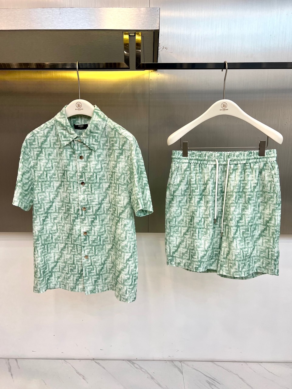 NO:840818,One set.  Fend Fendi, 2026 spring and summer new suit, combines the brand's iconic FF presbyopia texture with a fresh main tone to create a highly recognizable holiday style. The shirt adopts a classic lapel design, short sleeves are neatly cut, the button placket is simple and elegant, and the loose version brings unrestricted wear  The breathable fabric is light and skin-friendly, perfect for the rising temperatures in spring and summer. The matching shorts are designed with an elastic waistband and drawstring, which are highly tolerant and have a casual and loose trousers shape, making you feel casual and comfortable when walking around. The whole set uses the same color all-over pattern, which echoes up and down, and has strong visual unity, while retaining the street style.  The relaxed feeling of the trend, without losing the high-end luxury texture. Whether it is a seaside vacation, a city stroll or a summer party, this combination can easily make you the center of attention, demonstrating the fresh vitality of 2026. Wearing it as a set highlights the overall sense, and it can also be worn alone as a highlight of the style. It is a spring and summer clothing  An indispensable fashion item for the wardrobe, it can easily handle various occasions and show a leisurely fashionable attitude. 48-56 (model weighs 173,143 pounds, upper body size 50),, fendi, fendi, shorts, shirts, T-shirt,19860909一套. Fend芬迪、2026春夏新品套装,以清新主调融合品牌标志性FF老花纹理,打造出极具辨识度的度假风尚.衬衫采用经典翻领设计,短袖剪裁利落,纽扣门襟简约大气,宽松版型带来无束缚的穿着体验,透气面料轻盈亲肤,完美应对春夏升温.配套短裤采用松紧腰头与抽绳设计,包容性强,裤型休闲宽松,走动间尽显随性自在.整套采用同色系满印图案,上下呼应,视觉统一性强,既保留了街头潮流的松弛感,又不失高级轻奢质感.无论是海滨度假、城市漫步还是夏日派对,这套搭配都能让你轻松成为焦点,演绎属于2026的清新活力.成套穿着彰显整体感,单穿亦可作为造型亮点,是春夏衣橱不可或缺的时尚单品,轻松驾驭多种场合,展现从容不迫的时髦态度.48-56（模特173,143斤上身50码）,,fendi,fendi,shorts,shirts,T-shirt,,Men's clothing