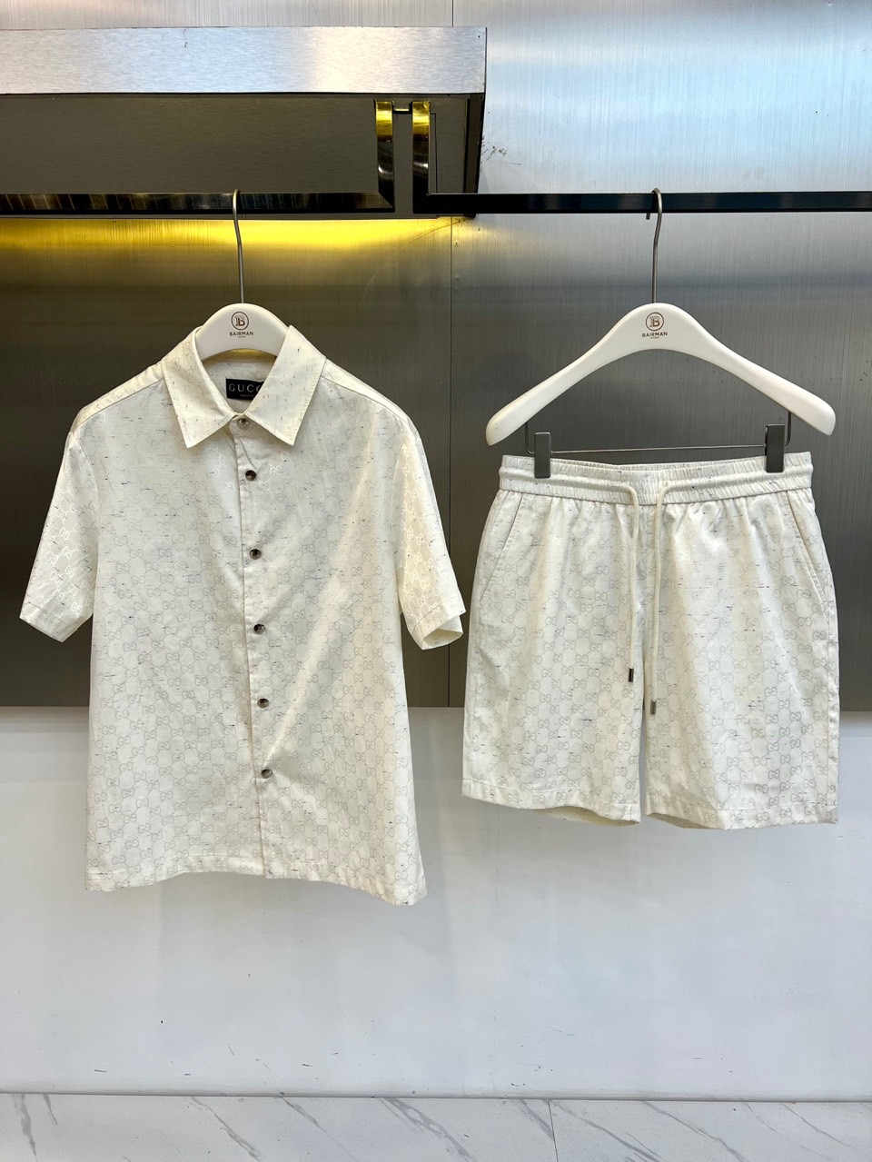 NO:840819,One set.  Gucci, the new spring and summer 2026 presbyopia suit, takes the classic double G print as the core element, with interwoven textures on the tonal base, highlighting the luxurious texture in a low-key manner. The top adopts a short-sleeved shirt style, the lapel design is matched with buttons, and the lines are neat and crisp, with a formal and casual atmosphere; the matching shorts use a drawstring elastic waist, a loose silhouette to modify the leg shape, comfortable and breathable suitable for hot weather. The overall style combines retro light and modern street, the presbyopic pattern is self-recognizable, upper  The body instantly enhances the style. The fabric is made of light and skin-friendly materials, with a smooth and draping feel. It can be easily controlled whether you are walking on vacation or commuting in the city. One set can be used for spring and summer outfits, eliminating the worry of matching, allowing you to maintain an elegant posture in the sun and breeze, and interpret a casual and comfortable fashion attitude. 48-56 (model 173, 143 pounds, upper body size 50),, gucci, gucci, shorts, shirts, T-shirt,19860909一套. Gucc古驰、2026春夏新品老花套装,以经典双G印花为核心元素,色调基底交织纹理,低调中彰显奢华质感.上衣采用短袖衬衫版型,翻领设计搭配纽扣,线条利落剪裁挺括,兼具正式感与休闲氛围；配套短裤选用抽绳松紧腰头,宽松廓形修饰腿型,舒适透气适合高温天气.整体风格融合复古轻奢与现代街头,老花图案自带辨识度,上身即刻提升造型层次.面料选用轻盈亲肤材质,触感顺滑垂坠有型,无论是度假漫步还是都市通勤都能轻松驾驭.一套搞定春夏穿搭,省去搭配烦恼,让你在阳光与微风中保持优雅姿态,演绎随性自在的时尚态度.48-56（模特173,143斤上身50码）,,gucci,gucci,shorts,shirts,T-shirt,,Men's clothing