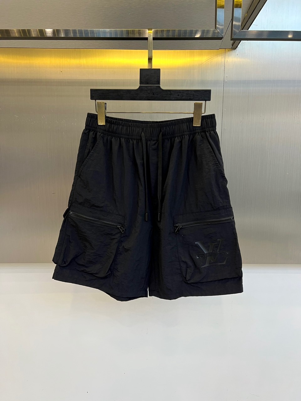 NO:918368,1v Vuitton, the new 2026 spring and summer cargo shorts, set the tone for summer vitality with eye-catching colors. The lightweight technical fabric creates a breathable and crisp texture, taking into account practical wear and comfort. The loose straight cut and elastic waist drawstring design accommodate all body shapes while providing a free and unrestricted wearing experience. The two-sided three-dimensional workwear large pockets are closed with exquisite zippers, which not only enhances functional aesthetics but also has practical storage functions, and shows ingenuity in every detail. The iconic L on the left leg  The V letter is low-key and luxurious, perfectly integrating brand recognition with street trends, presenting a cross-border style between high-end fashion and urban leisure. Based on workwear elements, these shorts are infused with luxury fashion genes, redefining the essential items in men's wardrobe in spring and summer, allowing comfort and style to naturally appear while roaming in the city, showing an avant-garde and uninhibited fashion attitude and exquisite lifestyle. M-4XL (model 173, 143 pounds, upper body size L),, louis  vuitton,shorts,198609091v威登、2026春夏新品工装短裤,以醒目色调定格夏日活力,轻盈科技面料打造透气挺括质感,兼顾实穿性与舒适度.宽松直筒剪裁配合弹力腰头抽绳设计,包容各种身形同时提供自由无束的穿着体验.双侧立体工装大口袋搭配精致拉链闭合,既强化机能美学又兼具实用收纳功能,细节处彰显匠心.左腿处标志性LV字母低调奢华,将品牌辨识度与街头潮流完美融合,呈现高级时装与都市休闲的跨界风格.这款短裤以工装元素为基调,注入奢华时尚基因,重新定义春夏男士衣橱必备单品,让舒适与型格在都市漫游中自然流露,展现前卫不羁的时尚态度与精致生活品味.M-4XL（模特173,143斤上身L码）,,louis vuitton,shorts,,Men's clothing