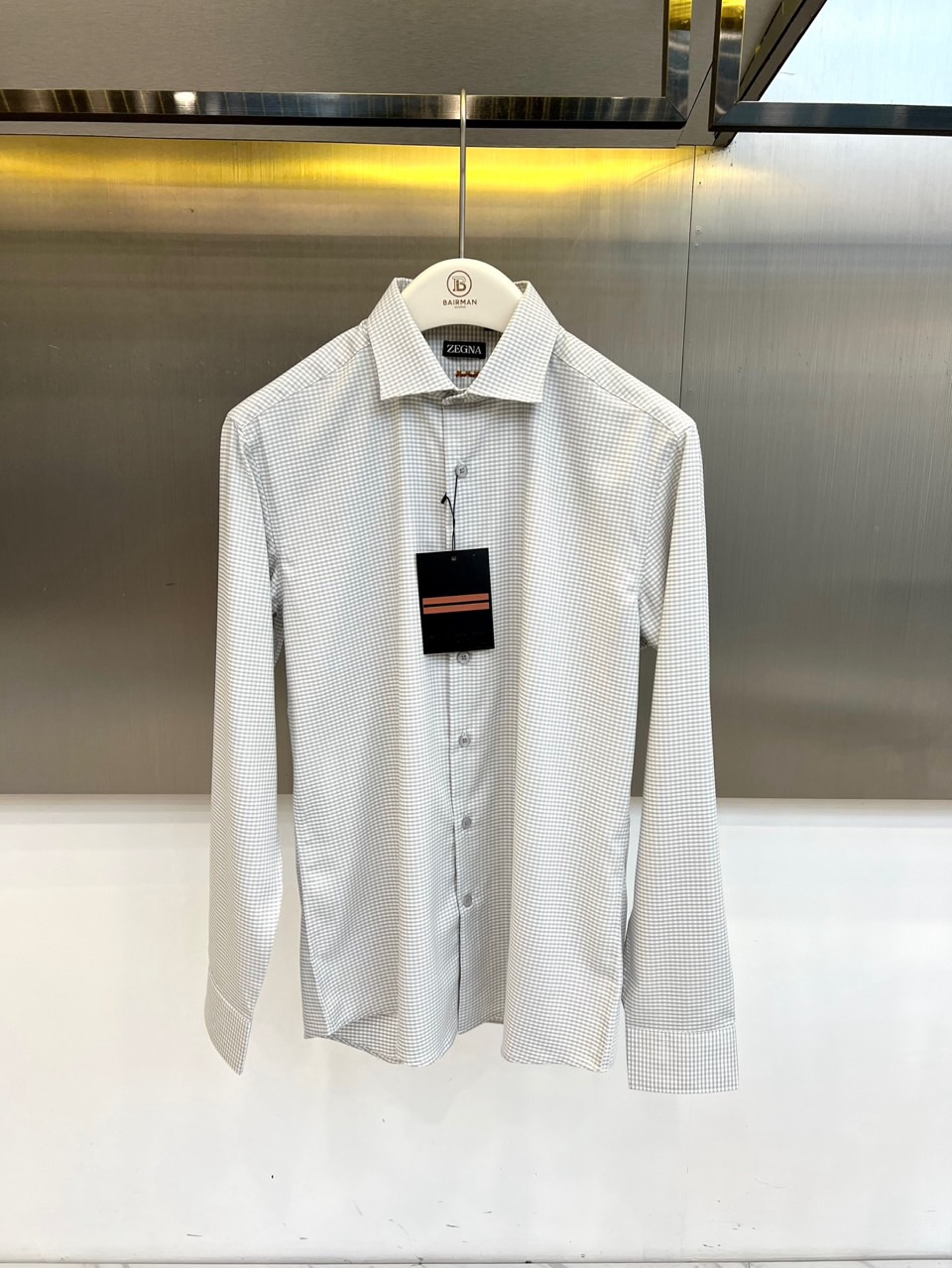 NO:842279,Zegna, the new 2026 spring and summer long-sleeved shirt, uses classic small plaid to interpret Italian gentleman aesthetics. The light and breathable fabric meets the wearing needs of spring and summer, bringing a refreshing and comfortable touch experience. It adopts a crisp Windsor collar design and an elegant collar.  Stretching and perfectly modifying the neck line, it can show a calm aura whether it is a business occasion or leisure time. The exquisite single-breasted placket and neat cuffs show the craftsmanship in the details. The slim tailoring outlines the body shape, while maintaining the rigor of formal wear.  Without losing the casualness of daily wear. The intertwined fine plaid pattern is fresh and elegant, breaking the monotony of solid colors while showing youthfulness and vitality, creating a layered spring and summer look. From early morning meetings to evening dates, this shirt has become a popular choice with its high-end texture and versatile attributes.  An indispensable exquisite item in urban men's wardrobe, it uses low-key luxury to interpret the dressing philosophy of contemporary elites, making every appearance confident and calm. 48-56 (model weighs 173,143 pounds, upper body size 50),,zegna,shirts,19860909Zegna杰尼亚、2026春夏新品长袖衬衫,以经典小格纹演绎意式绅士美学,轻薄透气的面料契合春夏季节穿着需求,带来清爽舒适的触感体验.采用挺括的温莎领设计,领型优雅舒展,完美修饰颈部线条,无论是商务场合还是休闲时光都能展现从容气场.精致的单排扣门襟搭配利落袖口,细节之处彰显匠心工艺,修身剪裁勾勒得体身形,既保持正式着装的严谨感,又不失日常穿搭的随性自在.交织的细格纹图案清新雅致,打破纯色单调的同时更显年轻活力,打造层次丰富的春夏造型.从清晨会议到傍晚约会,这件衬衫以高级质感与百搭属性,成为都市男士衣橱中不可或缺的精致单品,用低调奢华诠释当代精英的穿搭哲学,让每一次出场都自信从容.48-56（模特173,143斤上身50码）,,zegna,shirts,,Men's clothing