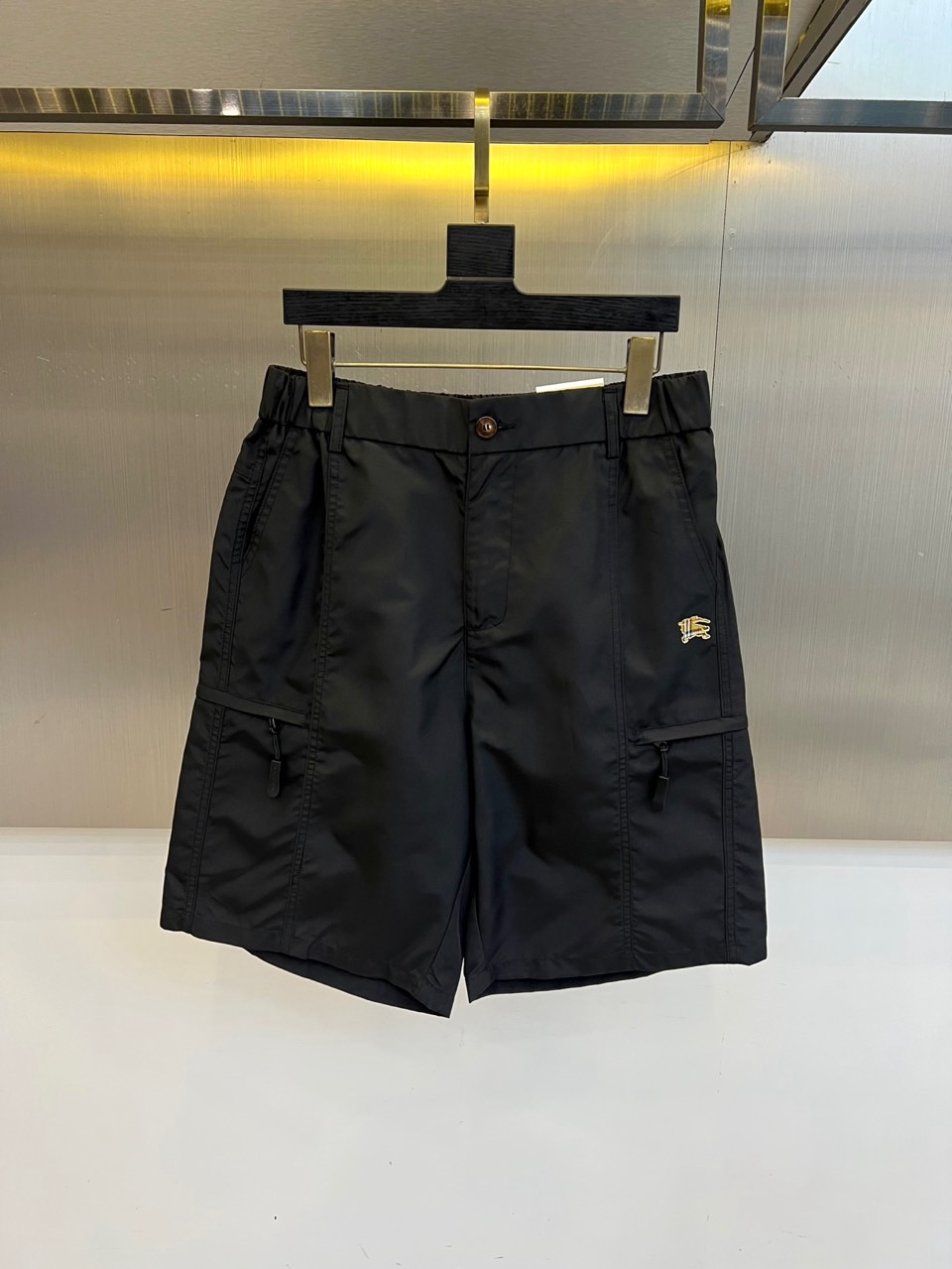 NO:918388,Burberry, 2026 spring and summer new cargo shorts, interpret urban leisure aesthetics with classic colors. It adopts a loose straight version, which is suitable for all body types and is comfortable to wear. The large-capacity cargo pockets on both sides are equipped with a drawstring design, which is not only practical and retractable  It can hold small items and add a functional and trendy feel. The semi-elastic splicing design of the waist combines the neatness of the waistline with the convenience of daily activities. The hidden pockets complete the overall shape. The fabric is made of light and breathable spring and summer exclusive material, which is smooth to the touch, anti-wrinkle, easy to care for, and stiff  They are stylish and not easy to collapse. The exquisite small logo on the left leg in the details shows quality and craftsmanship, and is simple yet recognizable. From commuting in the city to weekend outings, these shorts can provide you with a comfortable and fashionable wearing experience. They are an indispensable and versatile item for the spring and summer wardrobe.  The product allows daily wear to find the perfect balance between practicality and trend, showing a calm and confident urban style. M-4XL (model weighs 173,143 pounds, upper body size L),, burberry, burberry, shorts,19860909Bur巴宝莉、2026春夏新品工装短裤,以经典色调演绎都市休闲美学.采用宽松直筒版型,包容各种身材,穿着舒适自在.两侧大容量工装口袋配抽绳设计,不仅实用性强可收纳随身小物,更添机能潮流感.腰部半松紧拼接设计,兼顾收束腰线的利落与日常活动的便利,隐藏式口袋完善整体造型.面料选用轻薄透气的春夏专属材质,触感顺滑抗皱易打理,挺括有型不易软塌.细节处左腿精致小logo彰显品质匠心,简约而不失辨识度.从城市通勤到周末郊游,这条短裤都能为你提供舒适又时髦的穿着体验,是春夏衣橱不可或缺的百搭单品,让日常穿搭在实用与潮流间找到完美平衡,展现从容自信的都市型格.M-4XL（模特173,143斤上身L码）,,burberry,burberry,shorts,,Men's clothing