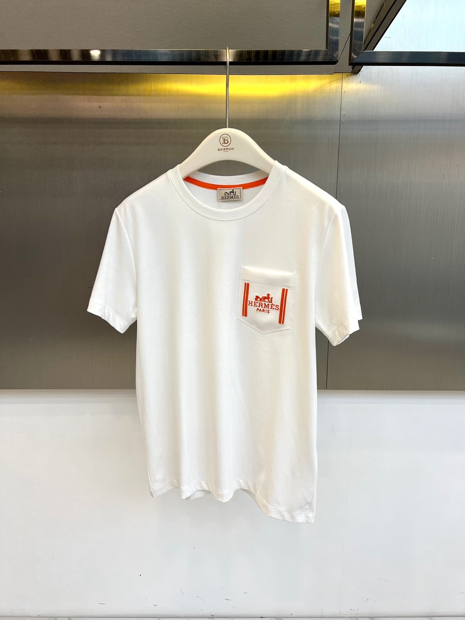 NO:858733,H Hermès, 2026 spring and summer new short-sleeved T-shirt, uses a solid color as the base color, incorporates the brand's iconic details, and interprets the perfect balance of French luxury and casual aesthetics. The round neck design is classic and versatile, and the contrast webbing on the inside of the collar is embellished, showing ingenuity in the details. Chest patch  The bag is decorated with classic horse-drawn carriage patterns and brand name embroidery, and lines outline the edges of the pocket, which not only adds visual hierarchy but also strengthens brand recognition. The fabric is made of high-count pure cotton, which is soft and skin-friendly, has good breathability and adapts to the changing climate of spring and summer. The cut is loose and moderate, and the dropped shoulders are designed to be slim.  It flatters the body shape, is refreshing and clean when worn alone, and looks casual and elegant when layered. The simple silhouette blends with high-end texture, which can be easily controlled whether it is daily commuting or weekend outings. The solid color tone is paired with iconic elements, revealing a luxurious style in a low-key manner, interpreting the calmness of modern urban elites  Taste is an indispensable textured item in the 2026 spring and summer wardrobe, which demonstrates extraordinary charm in a minimalist manner. 48-56 (model weighs 173,143 pounds, upper body size 50), hermes, T-shirt, tees, t-shirt,19860909H爱马仕、2026春夏新品短袖T恤,以纯色为底色,融入品牌标志性的细节,演绎法式奢华与休闲美学的完美平衡.圆领设计经典百搭,领口内侧撞色织带点缀,于细节处彰显匠心.胸前贴袋饰以经典马车图案及品牌字样刺绣,线条勾勒口袋边缘,既增添视觉层次又强化品牌辨识度.面料甄选高支纯棉,触感柔软亲肤,透气性佳,适应春夏多变气候.版型剪裁宽松适度,落肩设计修饰身形,单穿清爽干净,叠搭亦显随性优雅.简约廓形融合高级质感,无论是日常通勤还是周末出游,皆能轻松驾驭.纯色基调搭配标志性元素,低调中流露奢华格调,诠释现代都市精英的从容品味,是2026春夏衣橱不可或缺的质感单品,以极简之姿演绎非凡魅力.48-56（模特173,143斤上身50码）,,hermes,T-shirt,tees，t-shirt,,Men's clothing