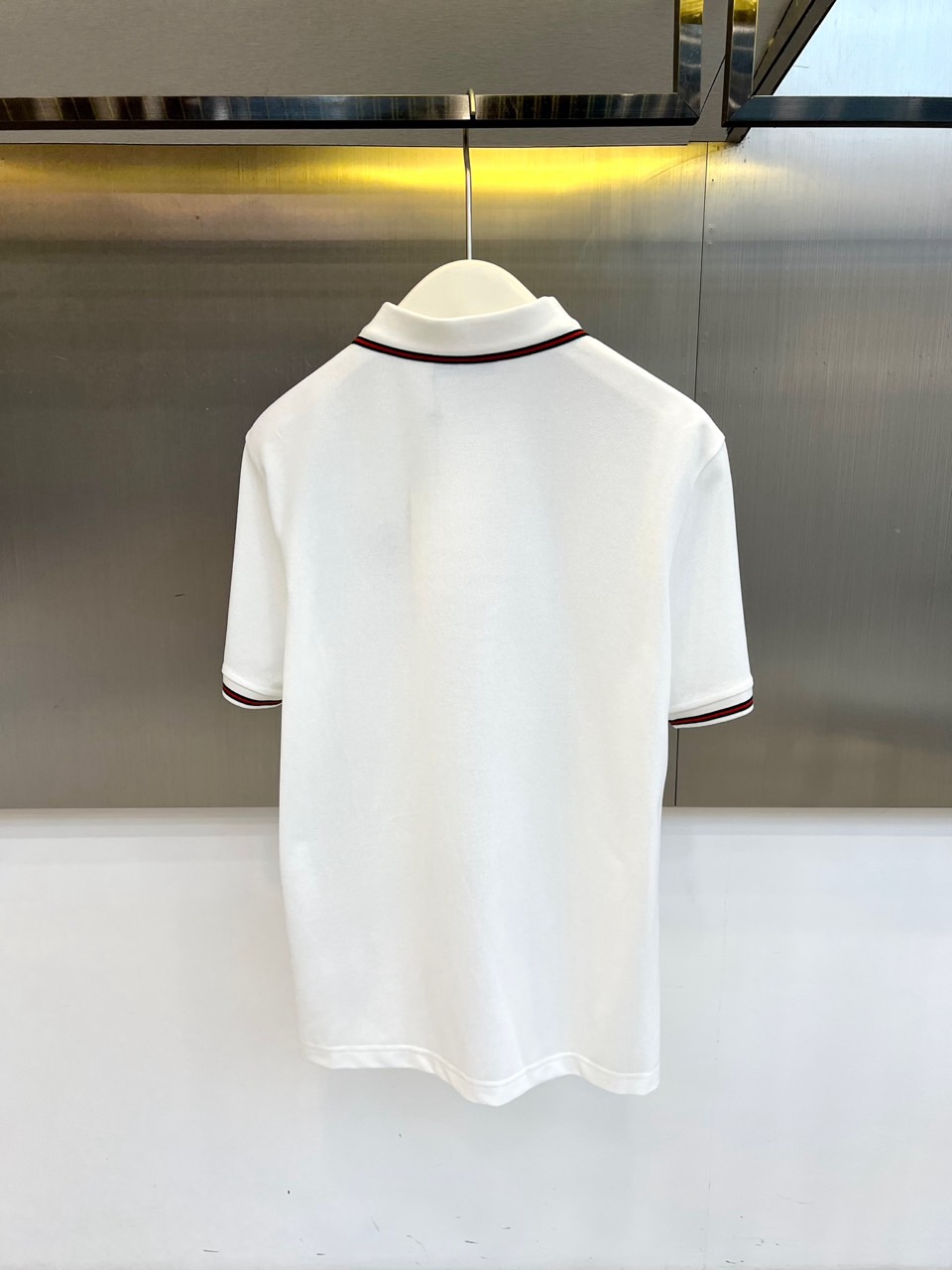 Gucci、2026春夏新品男士短袖Polo衫，延续经典翻领设计，以纯色为基调，领口与袖口点缀撞色条纹，