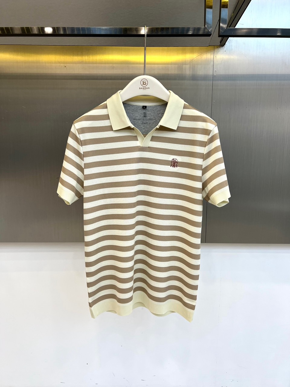 NO:903024,Brunello  Cucinelli-BC, the new 2026 spring and summer striped Polo shirt, reshapes the casual style with a classic lapel design. The contrasting intertwined horizontal stripes are simple yet layered, making it easy to manage commuting and vacation scenes. The exquisite embroidered logo on the left chest low-key highlights the brand texture, and the details are authentic. The fabric is made of 73 cotton + 27 polyester fiber blend, which is breathable and skin-friendly as well as stiff and durable. First-class craftsmanship ensures that every inch of the line is smooth and delicate, comfortable and burden-free to wear. Short-sleeved tailoring  It is neat, and the slightly arc design of the hem modifies the body shape, making it look slim but not tight, and is suitable for a variety of body types. The light and crisp fabric is not stuffy in spring and summer, and has excellent moisture absorption and perspiration performance, making you feel refreshed and comfortable every time you go out. This Polo is not only a must-have base for your wardrobe  A basic item, it is also a secret weapon to improve the overall texture of the outfit. It uses classic stripes and modern tailoring to collide to deduce your spring and summer elegance and vitality. 48-56 (model is 173, 143 pounds, upper body size 50), brunello  cucinelli,T-shirt,19860909Brunello Cucinelli-BC、2026春夏新品条纹Polo衫,以经典翻领设计重塑休闲风尚,撞色交织的横向条纹,简约而不失层次感,轻松驾驭通勤与度假场景.左胸处精致绣徽标,低调彰显品牌质感,细节处见真章.面料采用73棉+27聚酯纤维混纺,兼顾透气亲肤与挺括耐穿,一等品工艺确保每一寸走线平整细腻,穿着舒适无负担.短袖剪裁利落,下摆微弧设计修饰身形,显瘦不紧绷,适配多种身材.轻盈挺括的面料在春夏季节不闷热,吸湿排汗性能优异,让每一次出街都清爽自在.这件Polo不仅是衣橱必备的基础单品,更是提升整体穿搭质感的秘密武器,用经典条纹与现代剪裁碰撞,演绎属于你的春夏优雅与活力.48-56（模特173,143斤上身50码）,,brunello cucinelli,T-shirt,,Men's clothing
