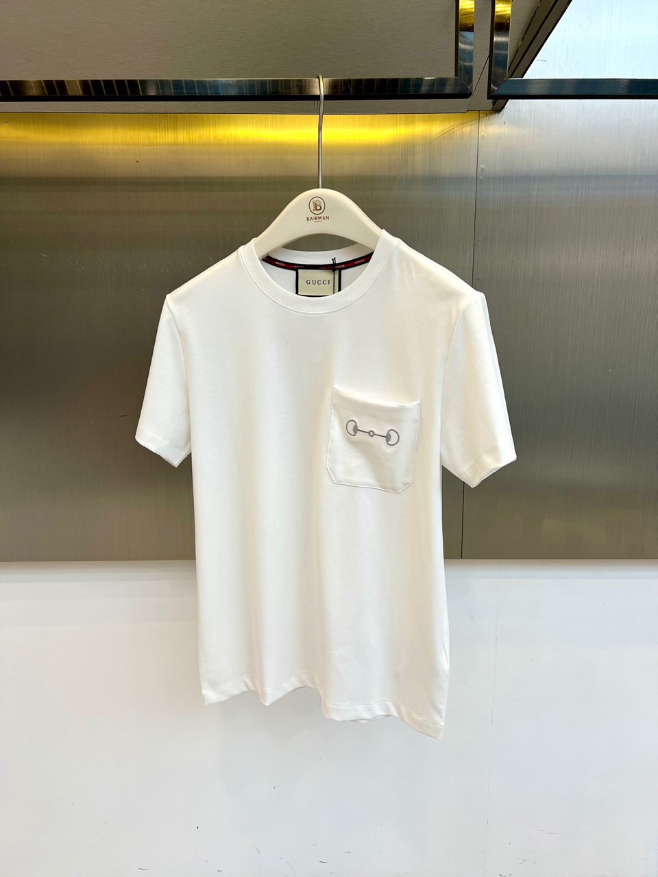 NO:903047,Gucci, the new short-sleeved T-shirt for spring and summer 2026, is based on solid colors and interprets minimalist aesthetics. The classic round neck design is paired with neat short-sleeved tailoring to create a refreshing and comfortable wearing experience. The left chest patch pocket design breaks the monotony and is cleverly integrated into the horsebit.  The elements are exquisite but not ostentatious, highlighting the brand's iconic details and high-end texture. It adds a sense of low-key luxury and shows the exquisiteness of Italian craftsmanship. Made of high-quality fabrics, it feels soft and breathable, fits the body shape but is not tight, and brings all-day comfort. Simple version  The model can easily control a variety of styles, and can be worn alone to show casual elegance, or layered to create a layered look, suitable for commuting, casual or light formal occasions. The 2026 spring and summer series continues the blend of classics and innovation, using pure tones and exquisite details to interpret the modern city.  Men's simple taste and extraordinary style are indispensable and versatile items in the wardrobe. 48-56 (model weighs 173,143 pounds, upper body size 50),, gucci, gucci, T-shirt, tees, t-shirt,19860909Gucc古驰、2026春夏新品短袖T恤,以纯色为基底,诠释极简主义美学.经典圆领设计搭配利落短袖剪裁,营造清爽舒适的穿着体验.左侧胸前贴袋设计打破单调,巧妙融入马衔扣元素,精致而不张扬,彰显品牌标志性细节与高级质感.增添低调奢华感,展现意式工艺的细腻考究.采用优质面料打造,触感柔软透气,贴合身形却不紧绷,带来全天候的舒适体验.简约版型轻松驾驭多种风格,可单穿展现随性优雅,亦可叠穿打造层次感造型,适配通勤、休闲或轻度正式场合.2026春夏系列延续经典与创新的交融,以纯净色调与精致细节,演绎现代都市男性的简约品味与不凡格调,是衣橱中不可或缺的百搭单品.48-56（模特173,143斤上身50码）,,gucci,gucci,T-shirt,tees，t-shirt,,Men's clothing