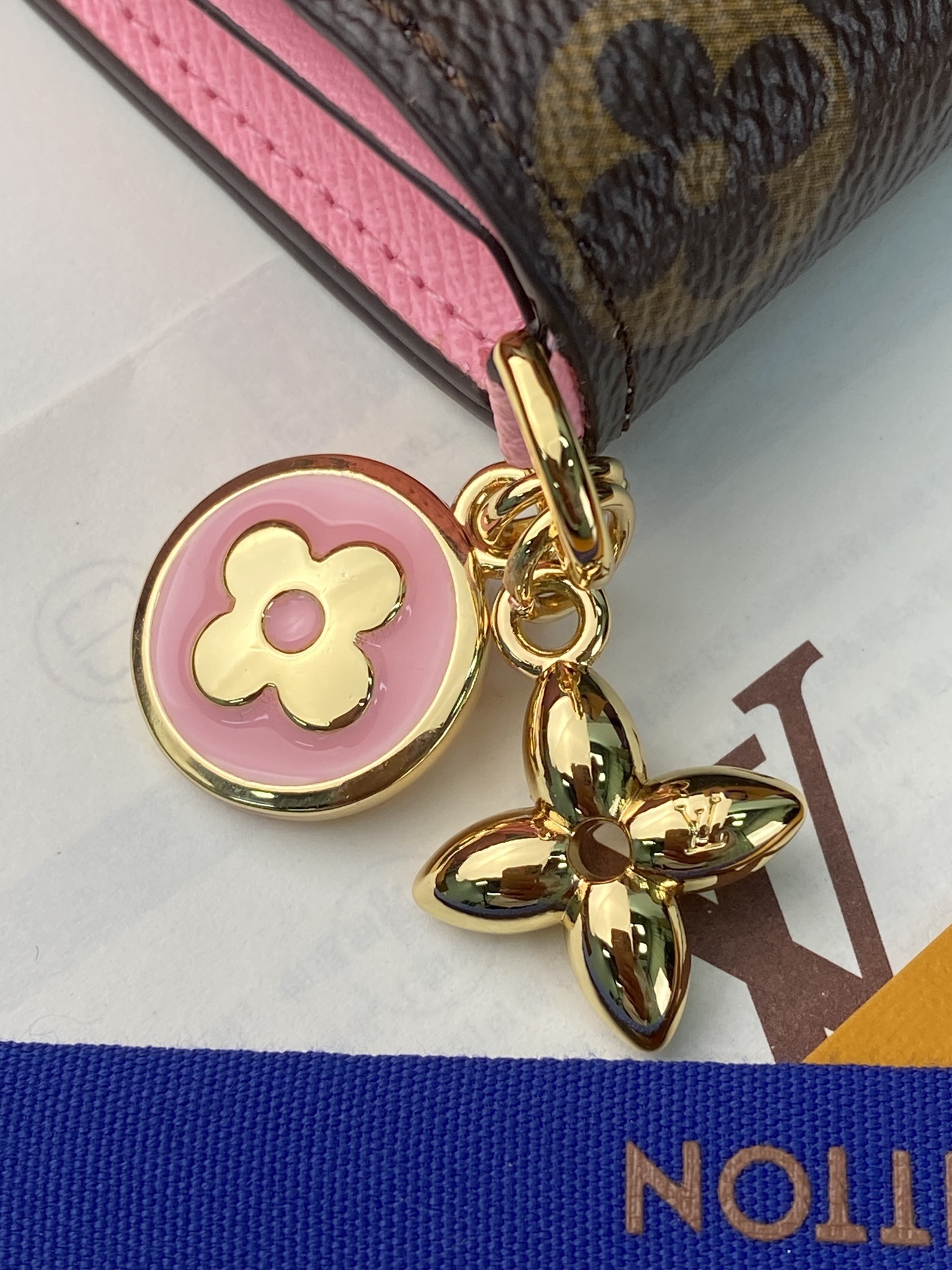M14628 粉色!这款小巧的配饰巧妙地融合了经典与时尚。它采用标志性的Monogram帆布材质制成,打