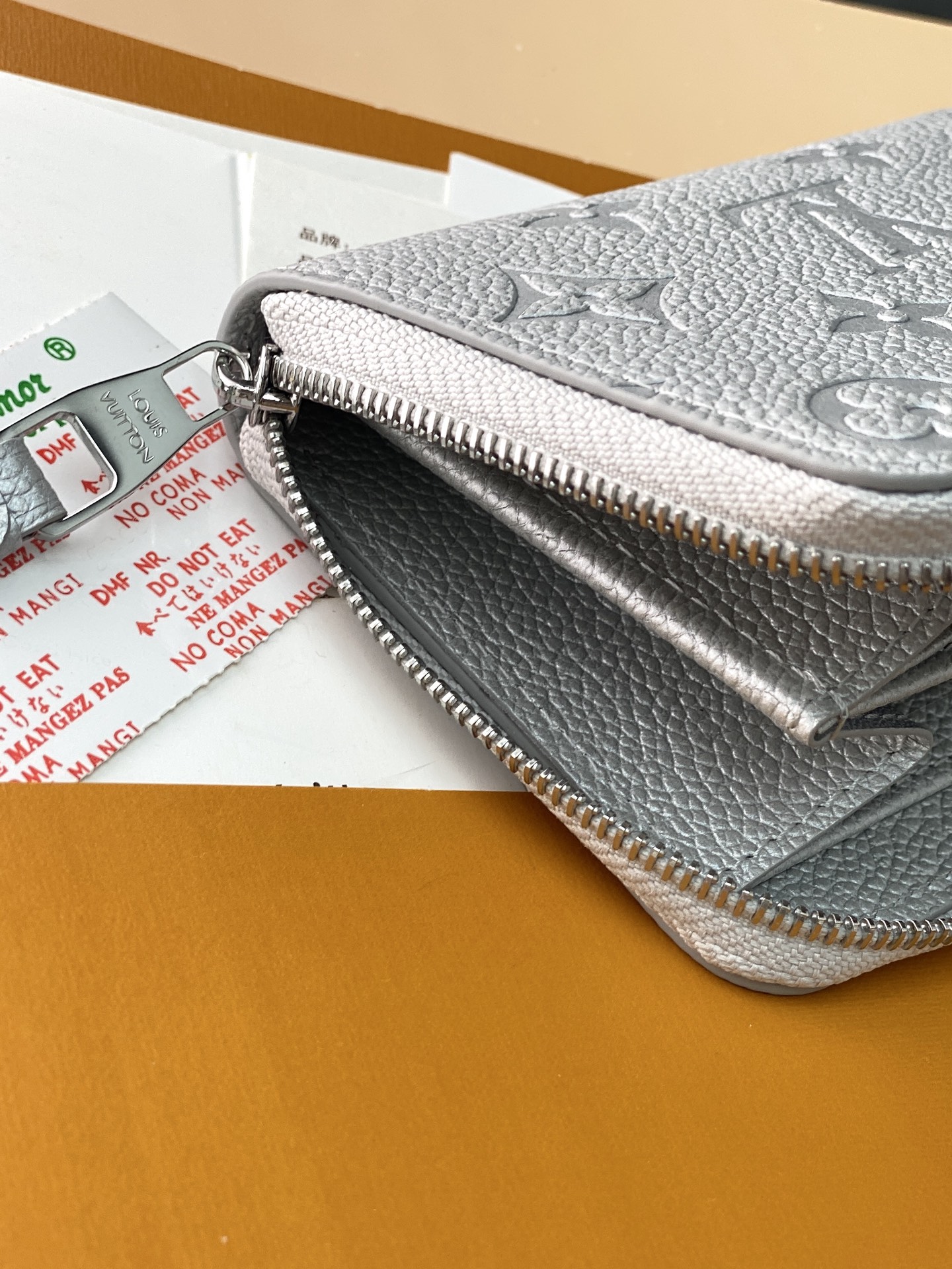 M60574 珠光银！此款拉链零钱包为都市人提供了最理想的选择。包身精巧紧凑，以亮银白色烘托精致质感。可