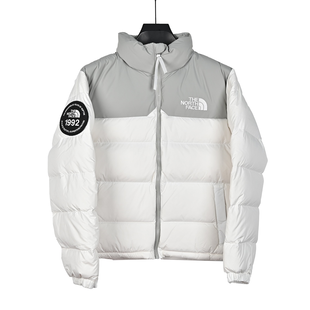 𝐓𝐡𝐞 𝐍𝐨𝐫𝐭𝐡 𝐅𝐚𝐜𝐞 北面 1992系列袖章魔术贴 30周年限定款/立领羽绒服

🔝产品配色： 黑色  白色

🔝产品尺码：XS  S  M  L  XL  XXL

🔝产品工艺：
1⃣️ 进口barudan/百灵达绣花机定制万针电绣，采用进口7号针，进口绣线，保证每字饱满、立体、清晰，可称最贵绣标！

2⃣️采用国标90白鸭绒填充，保暖性能更出色，轻便不厚重，压缩后的蓬松度恢复性好！ 

3⃣️原厂定制四级防水布料，独家采用原版一致单层布料做法【非市面通货内加胆布】，采用单层布料考验了布料及羽绒必须要达标，防止跑绒，并保证手感及膨松度，内里采用尼龙nylon双重双层封禁设计，不会出现任何跑绒现象，内置抽拉绳扣的可调节下摆，可防风防寒！ 

4⃣️拉链采用吉田YKK原厂定制，刻字清晰，质感完美顺滑.

5⃣️辅料及扣子均采用原版一样铜芯弹簧【非市面铁芯弹簧】

🔝产品包装：
独家定制旗舰店原版快递包装纸箱，胶带，还原ZP。区别以往超薄飞机盒，更加精美有档次。超大超厚超硬超有质感。完美应对快递暴力搬运，不会再发生以往纸箱压扁，客户收到箱子被破坏等情况。