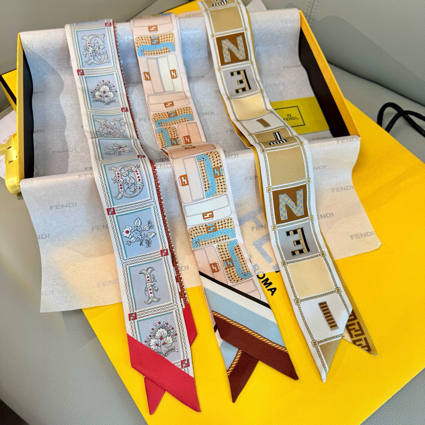 NO:379004,The most exciting scarf of Pfendi has finally come out, it is super recognizable. Wearing a hairband scarf on both sides. You can wear it on your neck and wrists or use it as a handbag accessories to add colorful colors. Organic mulberry silk material, with ivory and beige Fendi O'Lock pattern print on one side. The Fendi Mirror logo on the other side is decorated with the same color!  Material silk!  size105x5cm silk scarf, streamer, streamer, hair tie, fendi, fendi, fendi, real silk19860909批芬迪最让人心动的丝巾终于出来啦,超有辨识 双面佩戴束发带丝巾 双面可穿戴在脖子、手腕上,或当作手袋配饰、增添缤纷色彩.有机桑蚕丝材质,一面饰有象牙色和米色Fendi O'Lock图案印花.另一面饰有同色Fendi Mirror标志！ 材质真丝！size105x5cm 丝巾,飘带,飘带，发束,fendi,fendi,real silk,accessory