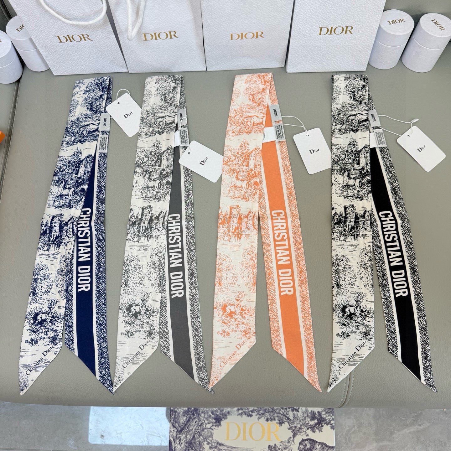 NO:882734,Dior's 25th new spring silk scarves are all beautiful, you can't pick them over. The slender version is matched with a pointed design, and the style is classic and chic. The back is decorated with a contrasting 'CHRISTIAN DIOR' logo jacquard strip pattern. It can be matched with various fashion styles, whether it is tied on the neck, wrist or handbag, it is an ideal finishing touch. Silk scarves, streamers, streamers, hair bundles, Dior19860909批 dior25年新款春季丝巾,款款都美,挑不过来了,修长版型搭配尖头设计,款式经典别致.背面饰以对比鲜明的“CHRISTIAN DIOR”标志提花条形图案.可与各种时尚造型搭配,无论系在颈部、手腕或手袋上,都是理想的点睛之笔.丝巾,飘带,飘带，发束,dior,accessory