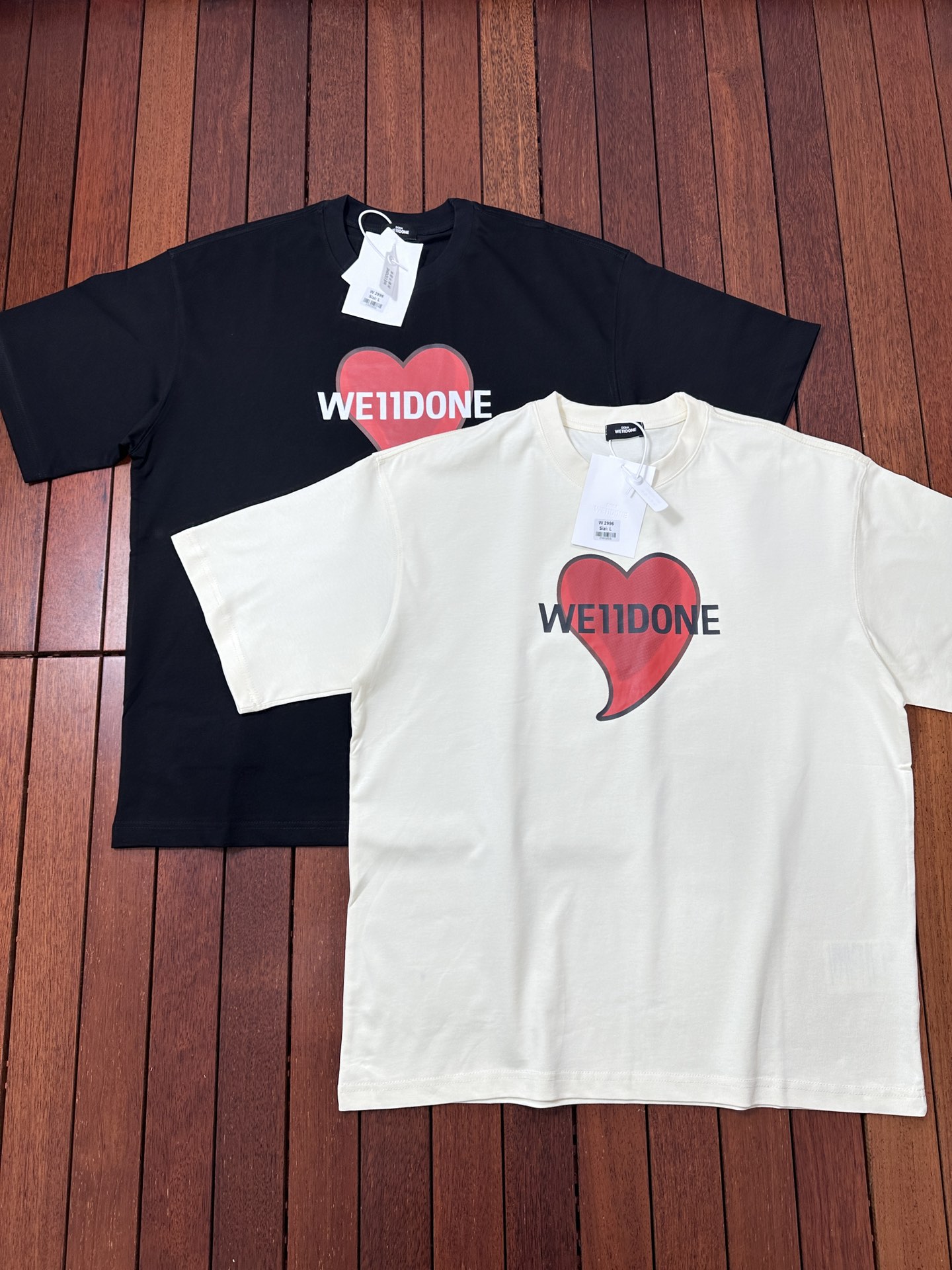 款号W159# -代购级韩国潮牌WE11DONE 红色爱心印花情侣宽松短袖T恤 男女同款- #面料采用定制280克织高密度食毛精梳棉,成衣两遍水洗处理,面料舒适亲肤无异感,面料垂感足,定织定染面料,螺纹2*2高弹加厚螺纹,领口包边走线为双线缝合,多重印花工艺,进口胶浆印花+进口荧光染料,全自动椭圆加热一体印花机,用8个网版菲林27次印刷,印花色彩牢度好,抗洗水不易裂开,定制辅料水洗标,二维码可扫码入官网! Color: 黑色 米杏色 肩宽 胸围 衣长 S 码 53 118 73 M码 54 122 75 L 码 55 126 77