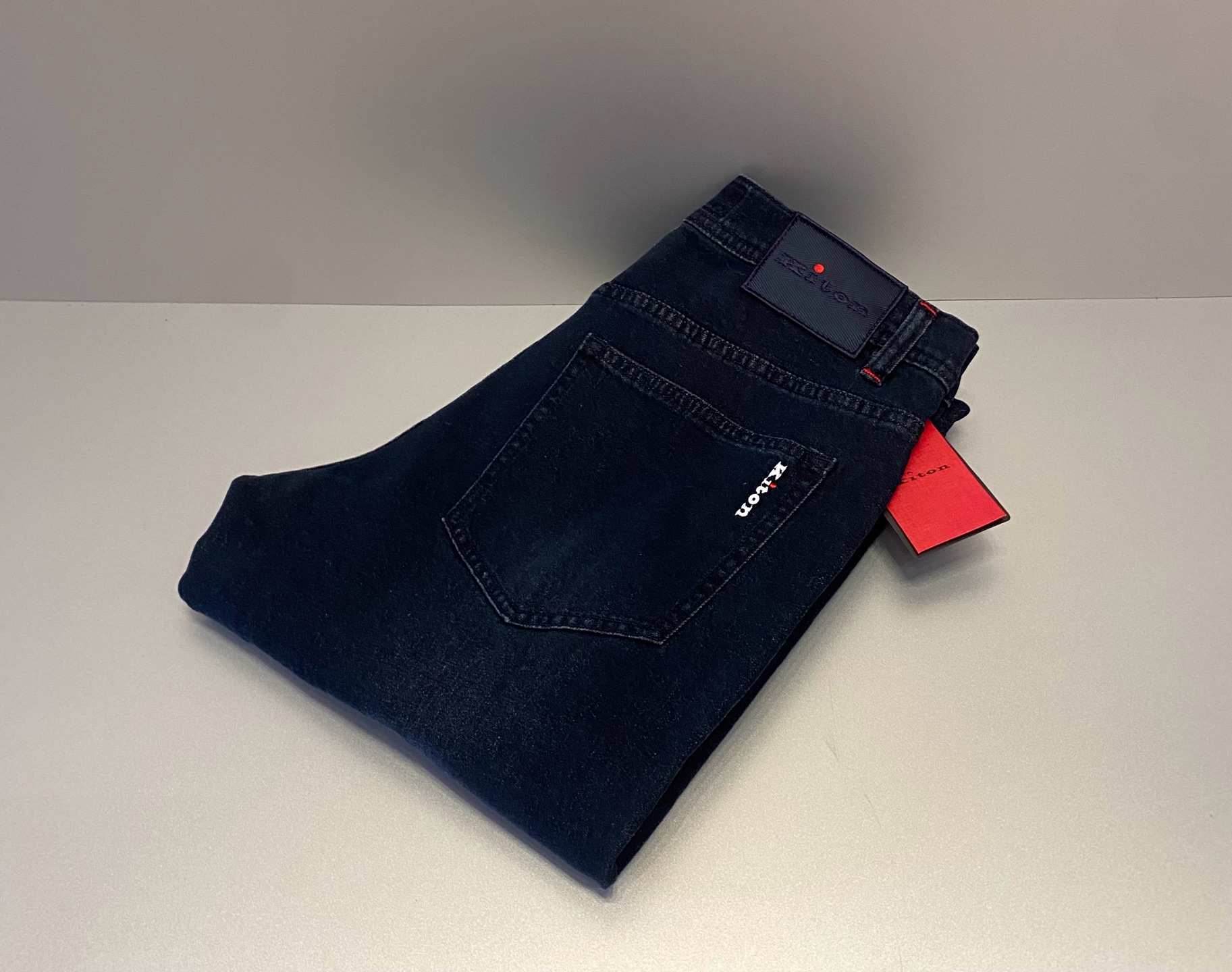 NO:756821,Kiton men's high-end slim-fitting men's trousers, which are among the top Italian ones. Size 30.31.32.33.34.36.38【26313】The brand logo is embossed with the word Kiton on the dark blue leather label on the back waist, the white Kiton brand name is embroidered on the right back pocket, and the iconic red contrasting details (buttons on the placket, stitching on the trouser ears, and red stripes on the inside of the trouser legs) run through the entire trousers, making them highly recognizable design elements of the brand.  ·Slim-fit mid-waist, classic five-pocket style, button placket, dark indigo/black gray washing process on the trousers, showing a low-key retro texture. Made of Japanese Kurabo custom-made thin denim, containing trace amounts of elastic fiber, which has both a stiff feel and wearing comfort. Fully hand-sewn, double-stitched reinforcement, and the red stripe (Kick Tape) on the inside of the trouser legs is the iconic craftsmanship detail.,,19860909奇顿男士高端修身男裤,属于意大利顶级. 码数30.31.32.33.34.36.38【26313】 品牌标识后腰深蓝色皮标压印 Kiton 字样,右后袋绣有白色 Kiton 品牌名,标志性红色撞色细节（门襟纽扣、裤耳缝线、裤脚内侧红条）贯穿全裤,是品牌辨识度极高的设计元素. ·中腰修身直筒（Slim-fit）,经典五袋款式,纽扣门襟,裤身采用深靛蓝/黑灰水洗工艺,呈现低调复古的质感. 采用日本Kurabo定制薄料丹宁布,含微量弹性纤维,兼具挺括感与穿着舒适度. 全手工缝制,双缝线加固,裤脚内侧红条（Kick Tape）是标志性工艺细节.,,,Men's clothing
