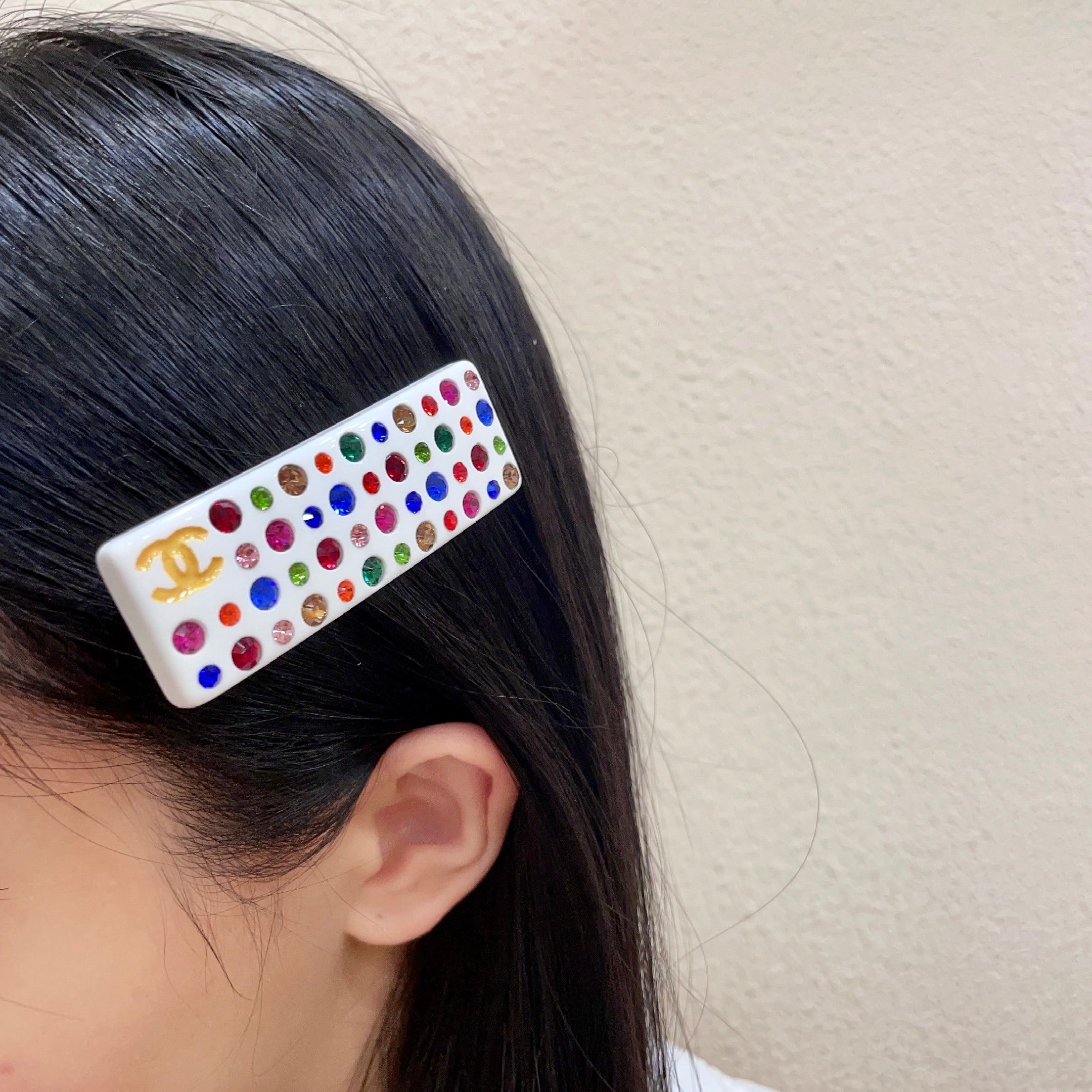 Chanel CC Logo Multicolor Crystal Resin Hair Barrette brooch White resin base with gold-tone interlocking CC logo multicolor faceted crystals in red blue green pink orange champagne and light pink hues 8cm length