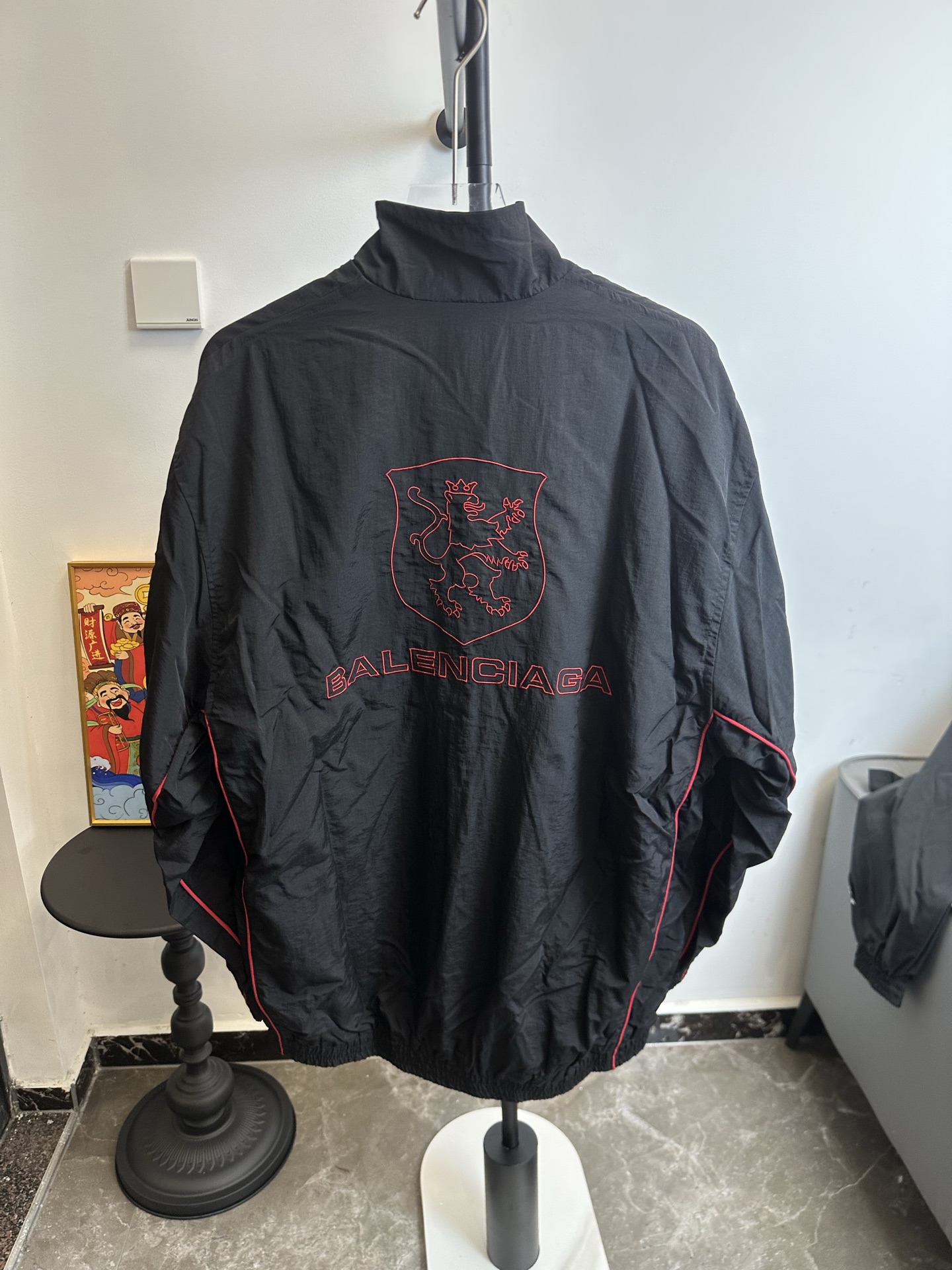 🅿️220【原单】
款号：TT61
【上新】Balenciaga 巴黎世家新款lion club曼联运动冲锋衣外套-

酷盖必备💥| Balenciaga 曼联刺绣冲锋衣
👦潮流玩家们，Balenciaga 这件黑色曼联刺绣冲锋衣真的杀疯了！
⚫经典黑色，百搭王者段位，怎么搭都不出错，轻松拿捏各种风格。冲锋衣版型挺括有型，穿上身气场瞬间两米八，户外感与时尚感并存。
曼联刺绣无疑是最大亮点👏，传承足球精神的同时，为这件冲锋衣赋予了独特的文化底蕴，精致刺绣在黑色基底上格外惹眼，高级感与个性齐飞。
功能性更是杠杠的👍，专业防水面料，下雨天、户外探险都能应对自如；透气设计让你运动出汗后也能保持干爽。拉链顺滑无阻，多口袋方便收纳随身小物件。


🔘颜色：黑色  
🔘Size：S  M  L  XL   现货秒发 详细尺码可查图9