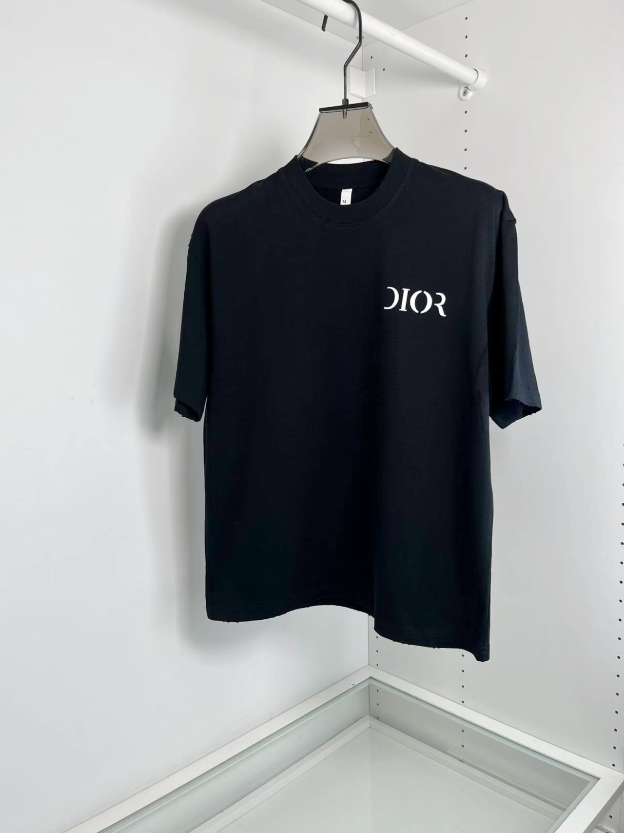 NO:130255,D*or Di*o Spring and Summer 2025 Letter Printing Small Broad Short Sleeve Round Neck T-shirt. The same style as the stars. The front and back letters Di*r deformed prints, the overall wear and aging feel makes the overall upper body trendy. Fashion Slightly Broad Cutle Short Front and Long Back, with side slits The fabric is made of 230 grams high-woven cotton bamboo jersey knitted cotton fabric, which is thicker than summer single product fabric. The upper body is skin-friendly, breathable, and can be crisp and stylish. Full-quality order [Color] Black White [Code] M-2XL Try on 170-140 for M, T-shirt,tees, t-shirt,alexander wang19860909D*or迪*奥 2025春夏 字母印花微阔型短袖圆领T恤衫.明星同款.前后字母Di*r变形印花,整体磨破做旧感 让整体上身潮流 时尚 微阔的剪裁 前短后长,侧边开叉 面料采用230克高织棉质竹节平纹针织棉质面料,相较夏季单品面料有所加厚.上身 亲肤 透气的同时又能挺括有型 全品相订单【颜色】黑色 白色【码数】M-2XL 试穿170-140穿M合适,,T-shirt,tees，t-shirt,alexander wang,Men's clothing