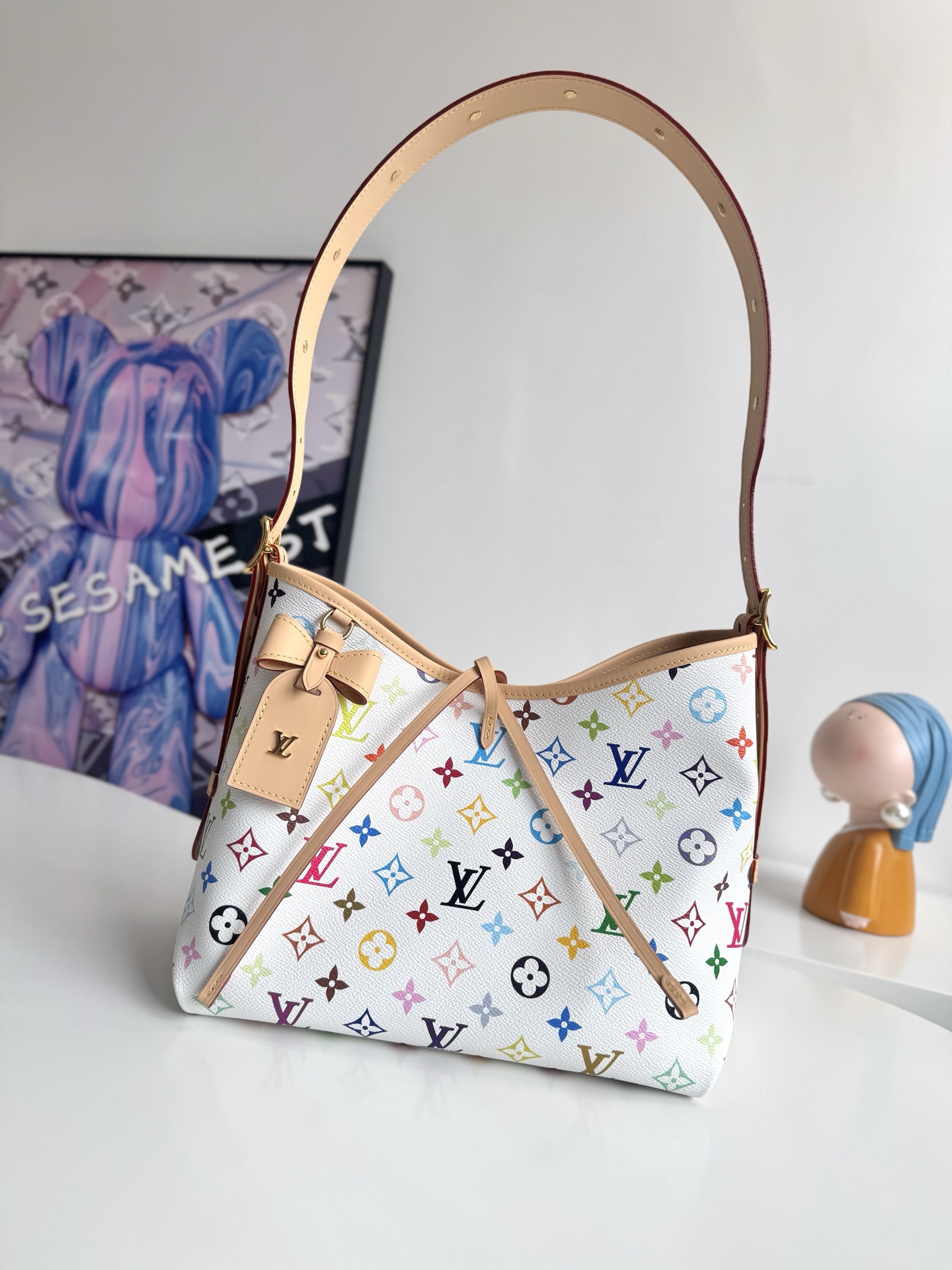 LV x TM CARRYALL 小号手袋 M Size:xx 本款 CarryAll 小号手袋出自路易威登 x 村上隆再版系列，为 Monogram 涂层帆布巧妙融入日本艺术家的明丽色调。牛皮革饰边勾勒贴身构型，名牌点缀雅致蝴蝶结细节。0QD