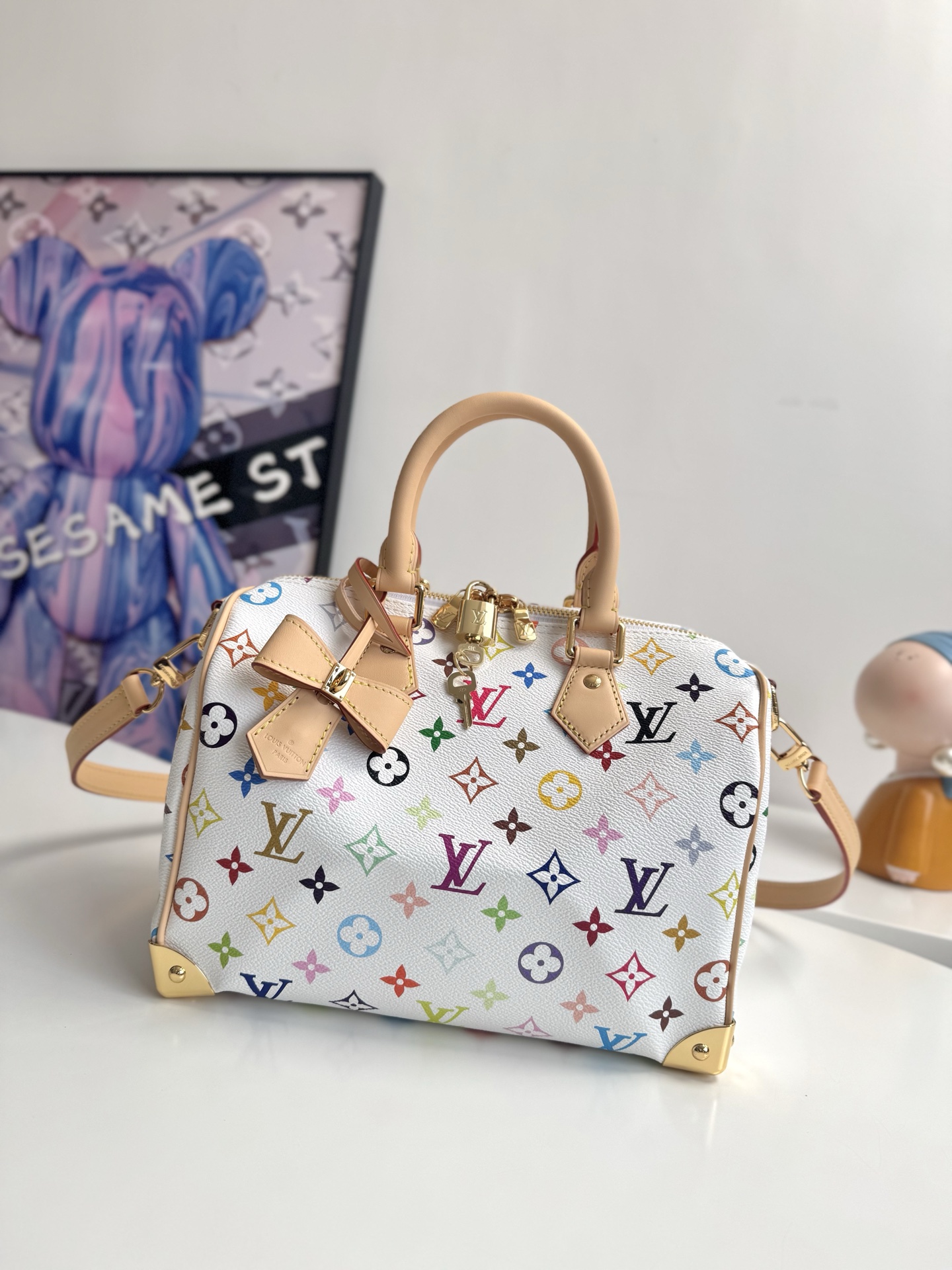 LV x TM SPEEDY BANDOULIÈRE  手袋 MYE Size:xx 本款 Speedy Bandoulière  手袋为经典 Monogram 图案渲染日本艺术家村上隆笔下的明丽色调，与蝴蝶结造型钥匙包一道彰显路易威登 x 村上隆合作系列的灵动风采。牛皮革塑造 Toron 手柄和可拆卸并调节的肩带，耀目挂锁和包角援引品牌行李箱元素。0QW