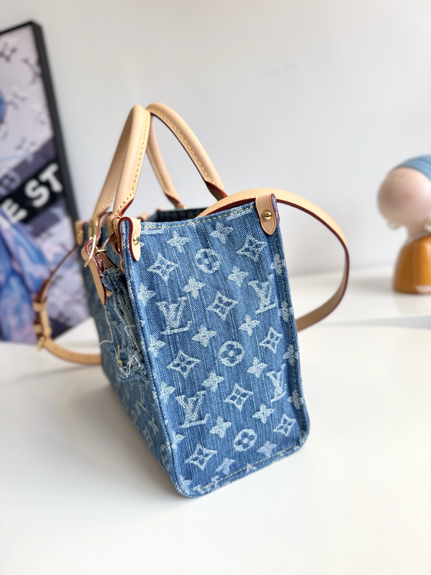 600海外原单M14633独家实拍！本款 OnTheGo 小号手袋为经典 Monogram 丹宁布勾勒牛皮革饰边，搭配耀目金属件和磁扣翻盖开合。充裕空间可容纳平板电脑和日常所需，可拆卸肩带实现手提或斜挎。尺寸：25×19×11.5cm