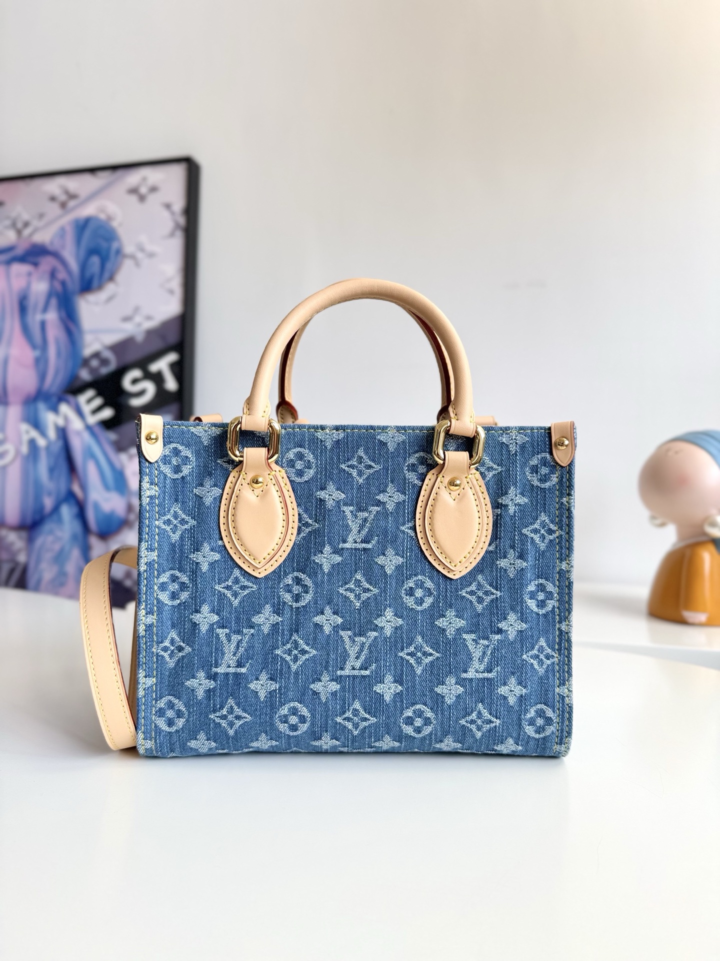 600海外原单M14633独家实拍！本款 OnTheGo 小号手袋为经典 Monogram 丹宁布勾勒牛皮革饰边，搭配耀目金属件和磁扣翻盖开合。充裕空间可容纳平板电脑和日常所需，可拆卸肩带实现手提或斜挎。尺寸：25×19×11.5cm