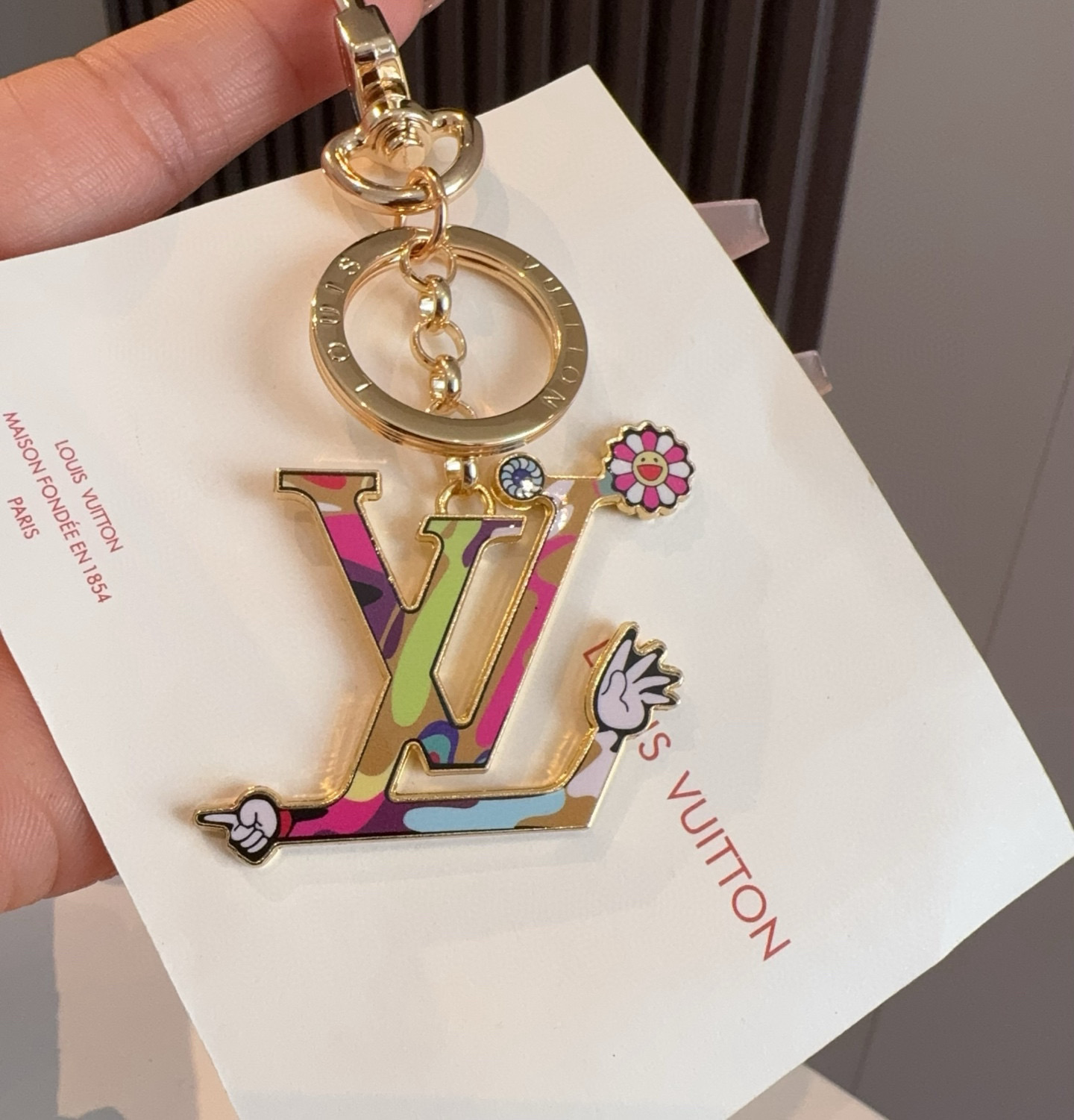  。LV村上隆钥匙扣包包挂饰 LV X TM LV ICONIC
SUPERFLAT 钥匙扣
路易威登再