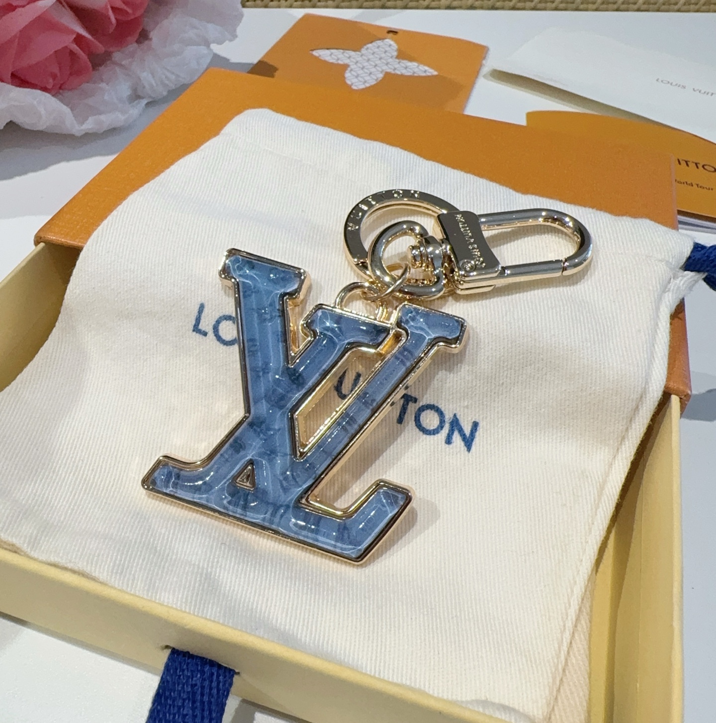  。LV 钥匙扣 包包挂件配饰Gloss 钥匙扣将有机玻璃 LV 字母镶嵌金属之中，其上点缀 Nanog