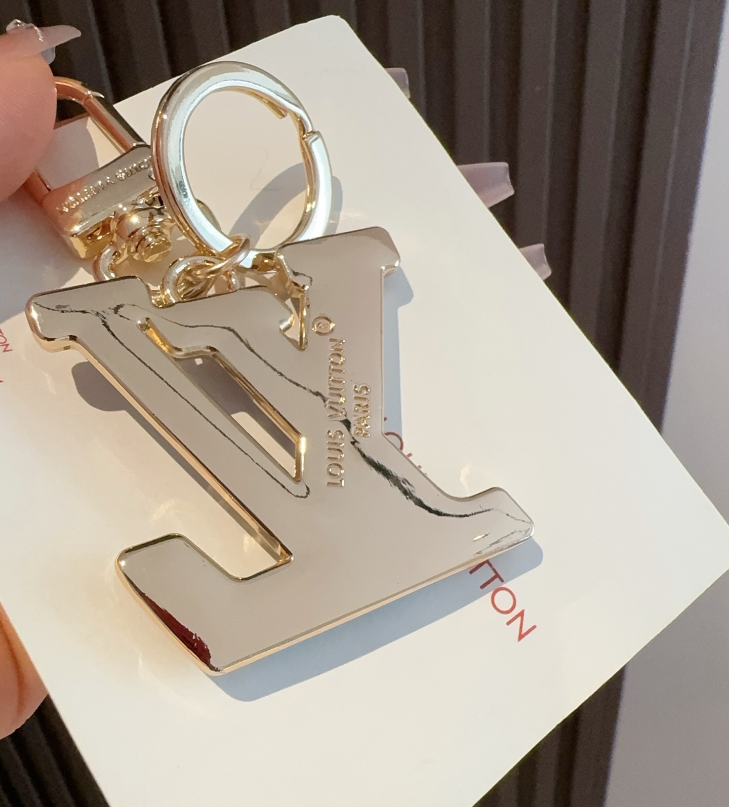  。LV 钥匙扣 包包挂件配饰Gloss 钥匙扣将有机玻璃 LV 字母镶嵌金属之中，其上点缀 Nanog