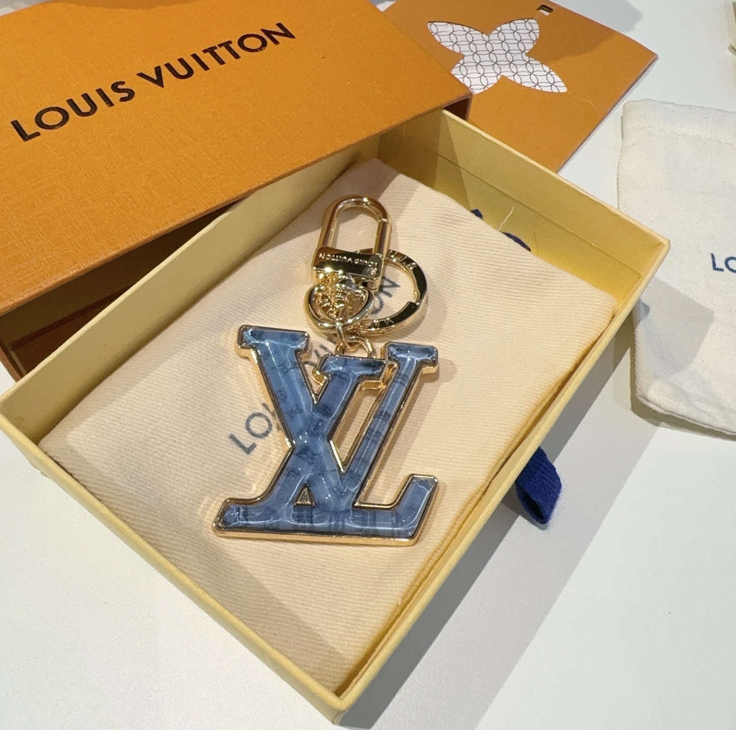  。LV 钥匙扣 包包挂件配饰Gloss 钥匙扣将有机玻璃 LV 字母镶嵌金属之中，其上点缀 Nanog