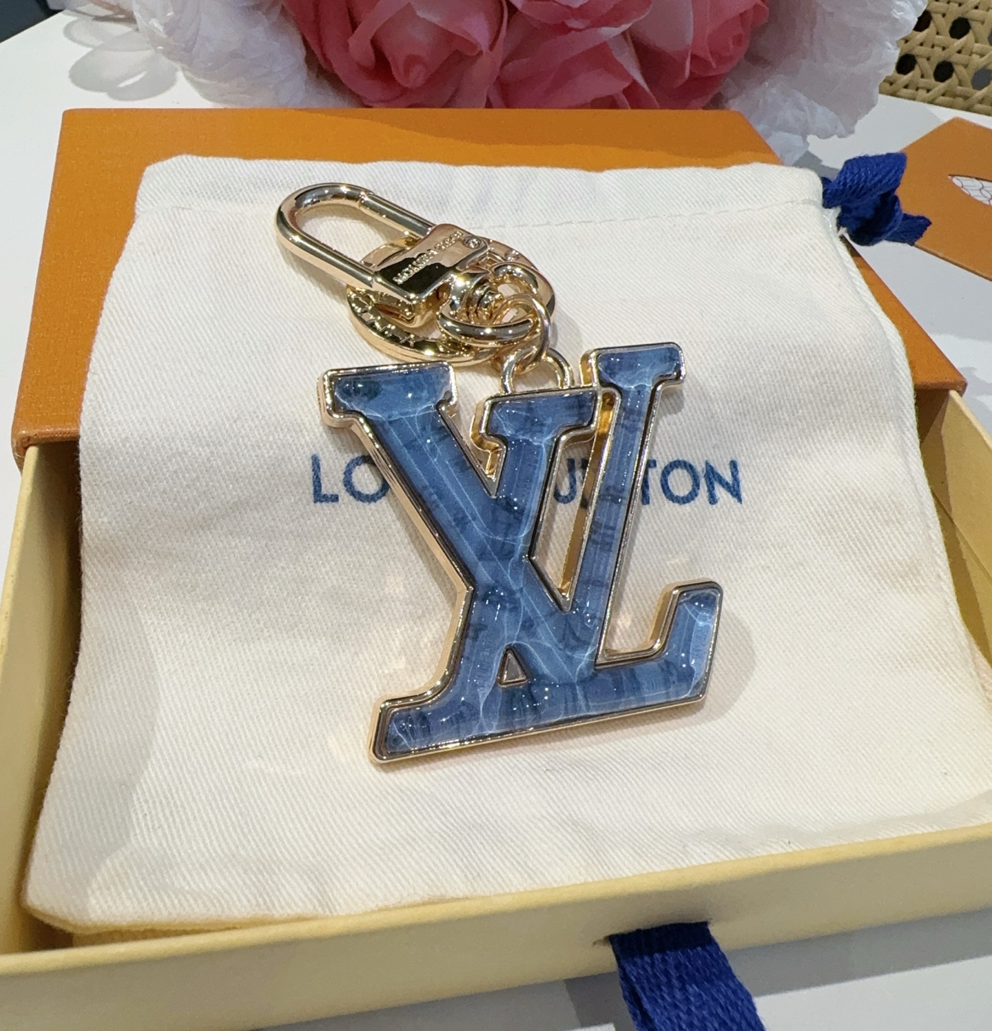 。LV 钥匙扣 包包挂件配饰Gloss 钥匙扣将有机玻璃 LV 字母镶嵌金属之中，其上点缀 Nanog