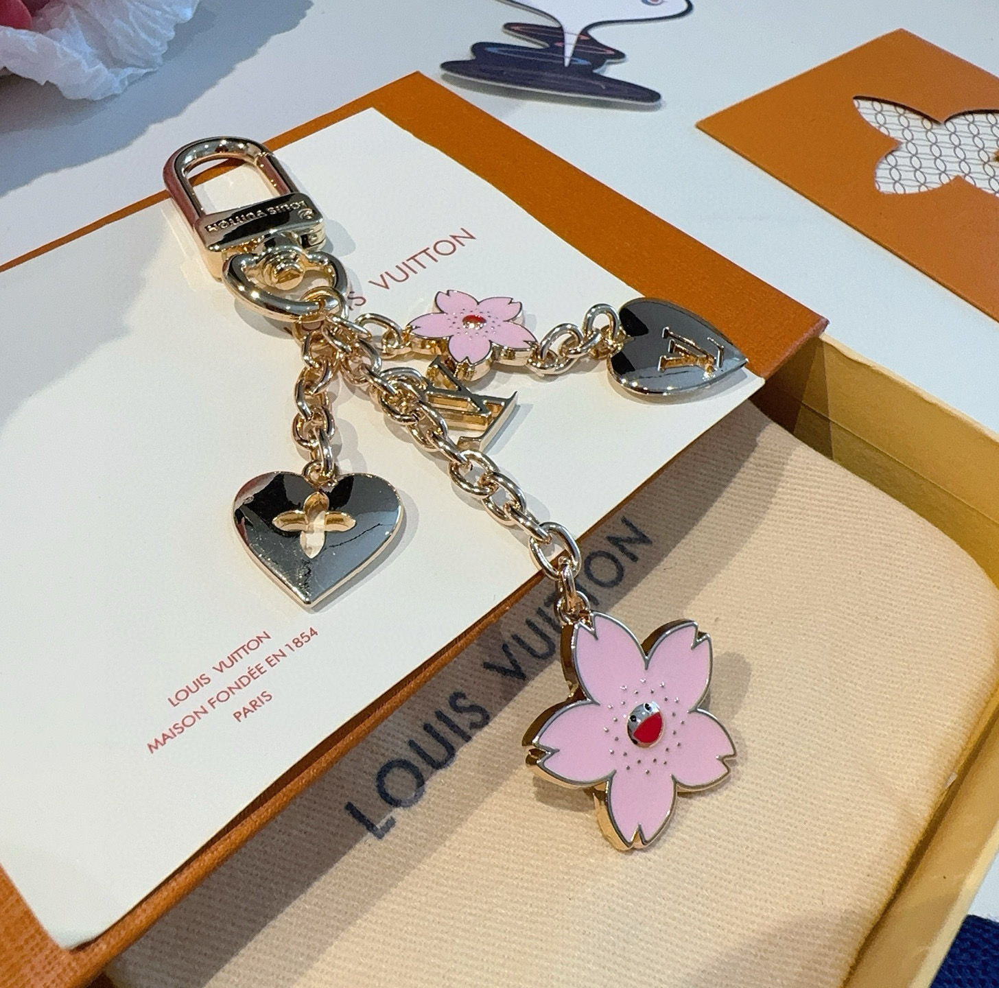  Lv钥匙扣 村上隆合作款樱花🌸钥匙扣 包饰挂件
本款链条包饰出自路易威登x村上隆复刻系列，为耀目链条交