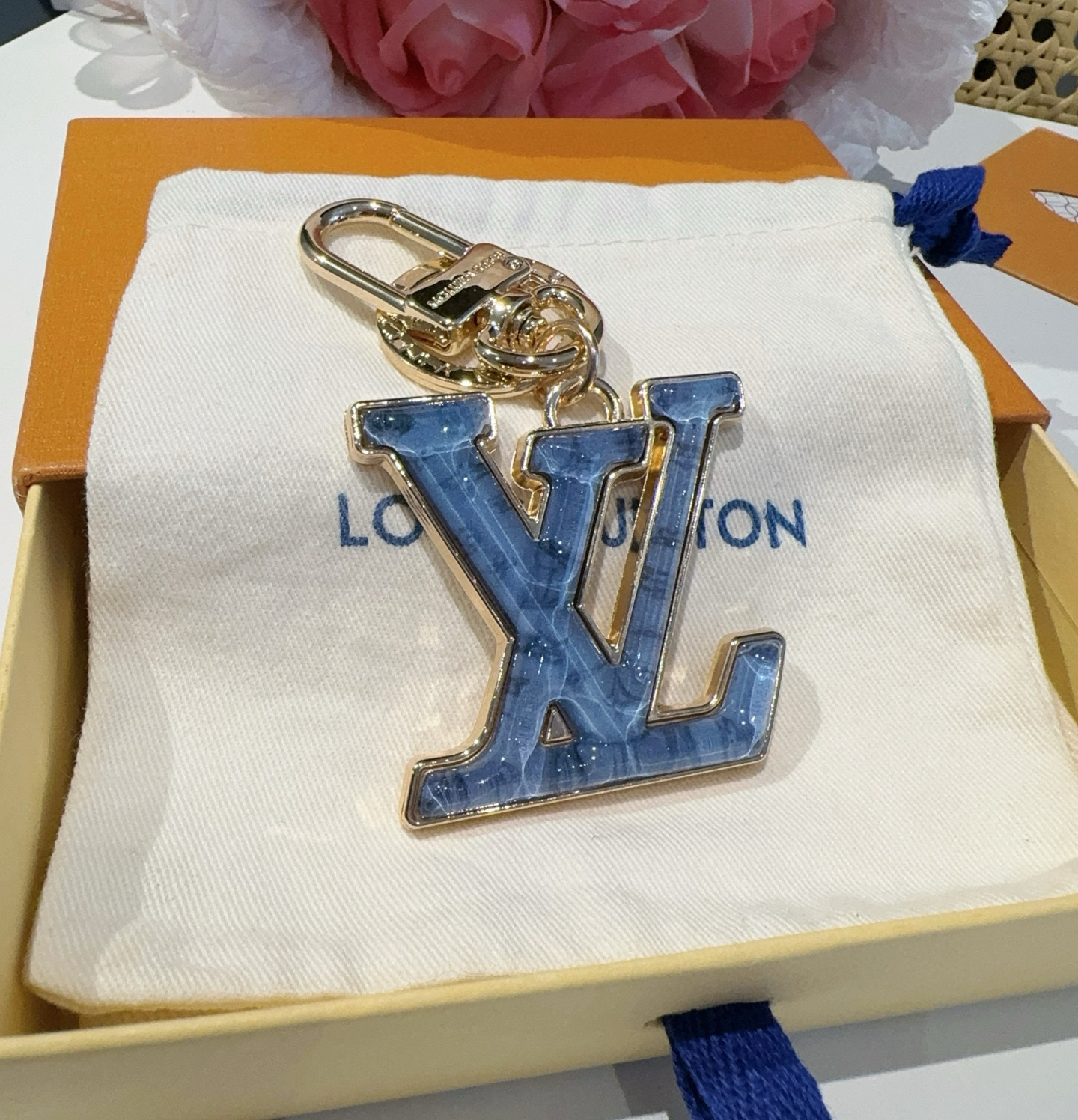  。LV 钥匙扣 包包挂件配饰Gloss 钥匙扣将有机玻璃 LV 字母镶嵌金属之中，其上点缀 Nanog
