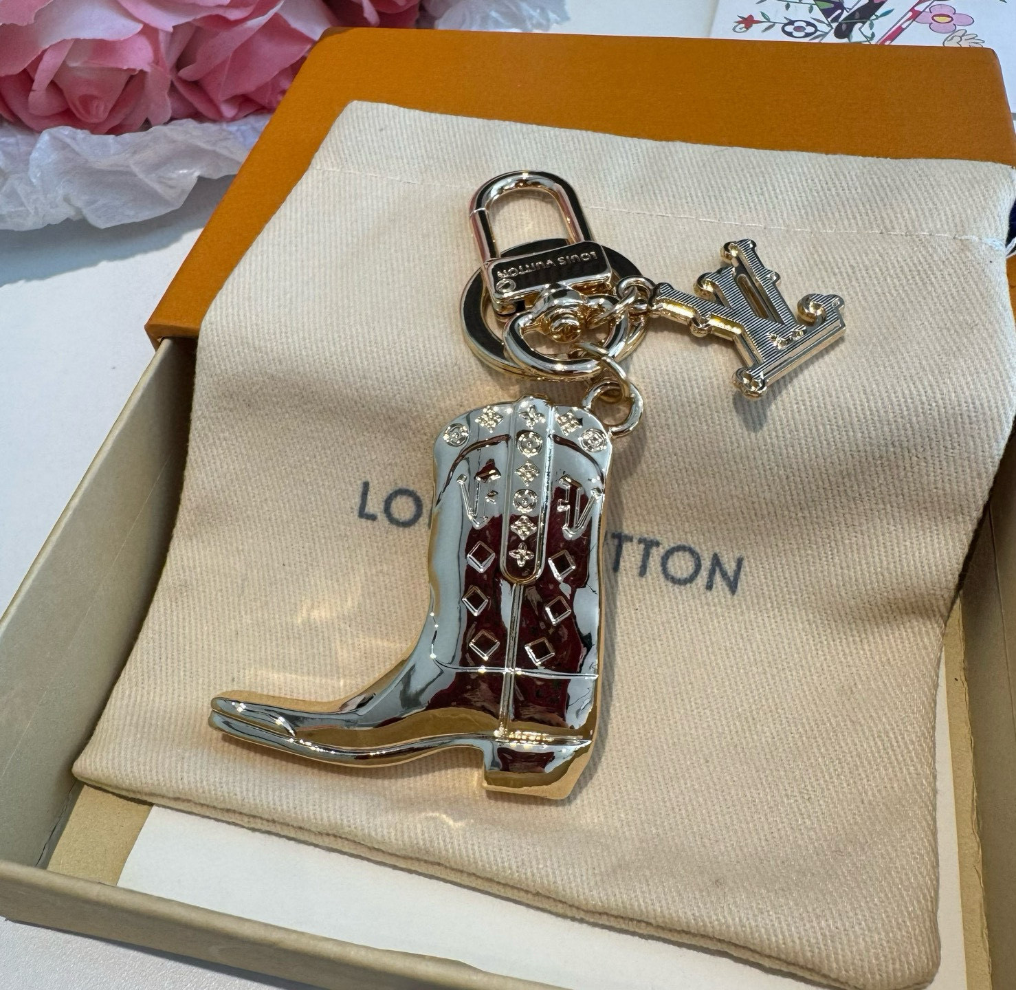 。LV钥匙扣 靴子挂件车钥匙挂饰，品牌经典标识巧妙嵌入链环之间。LV字母装饰于一端优雅垂坠，弹簧扣实现轻