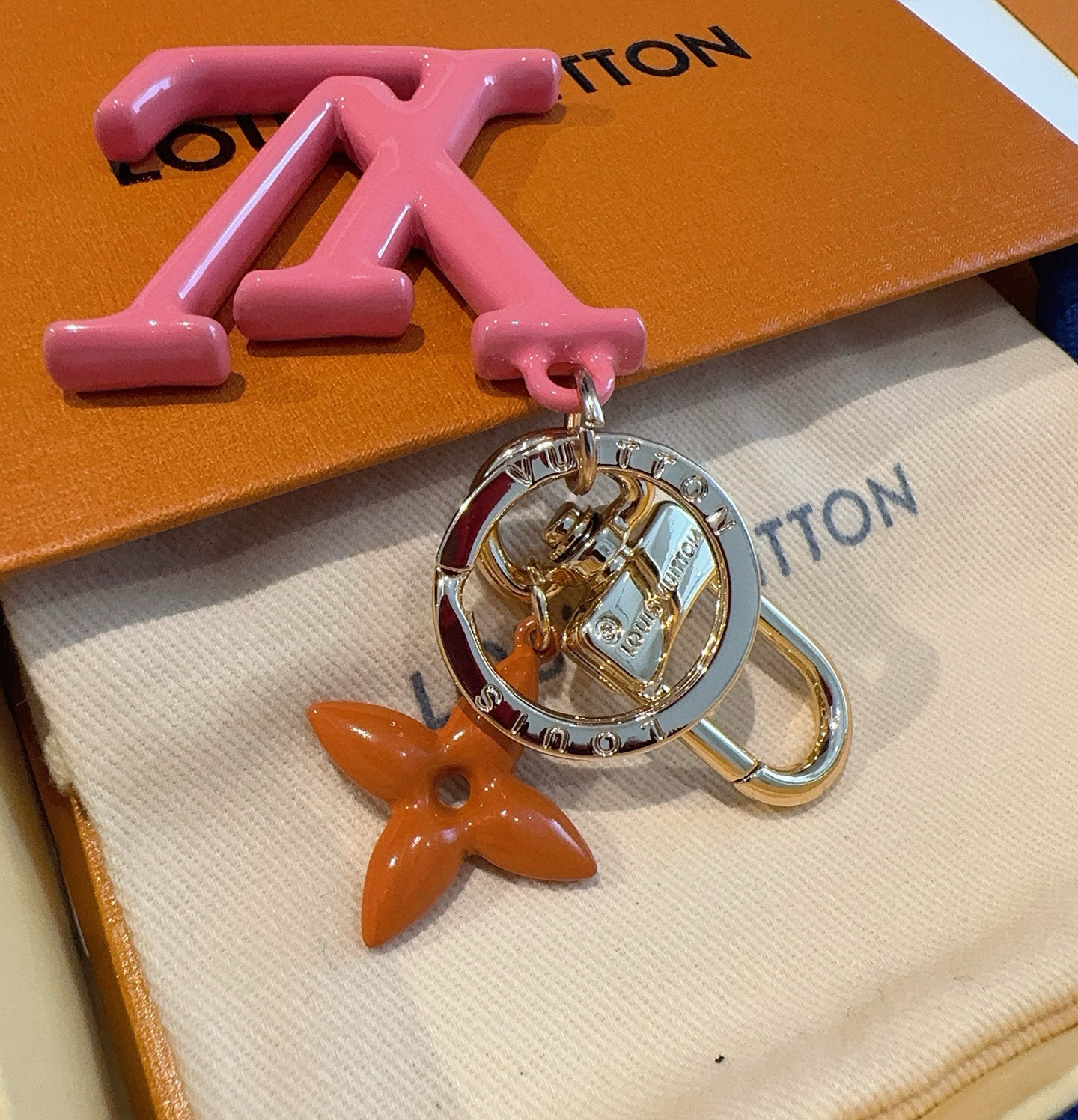 P75 🔥LV钥匙扣珐琅工艺LV字母挂件 Pop Flower包和钥匙扣的魅力非常适合为皮革配饰增添标志性的色彩，其特点是金色金属钩环，点缀着充满活力的LV首字母和会标花吊坠符咒花押和首字母LV
钥匙扣M01076