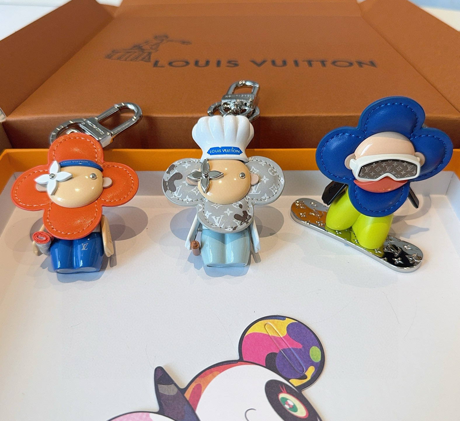 
P125 🔥Louis Vuitton/路易威登LV新品钥匙扣包包挂饰 车钥匙挂件薇薇安滑板⛷️
官网 M00965 LV小吉祥物&rdquo;迷你护目镜和滑雪板呈现经典 Monogram 图案
哑光皮革
花瓣和衣身临 羽绒夹克的蓬松感，真的好看😀