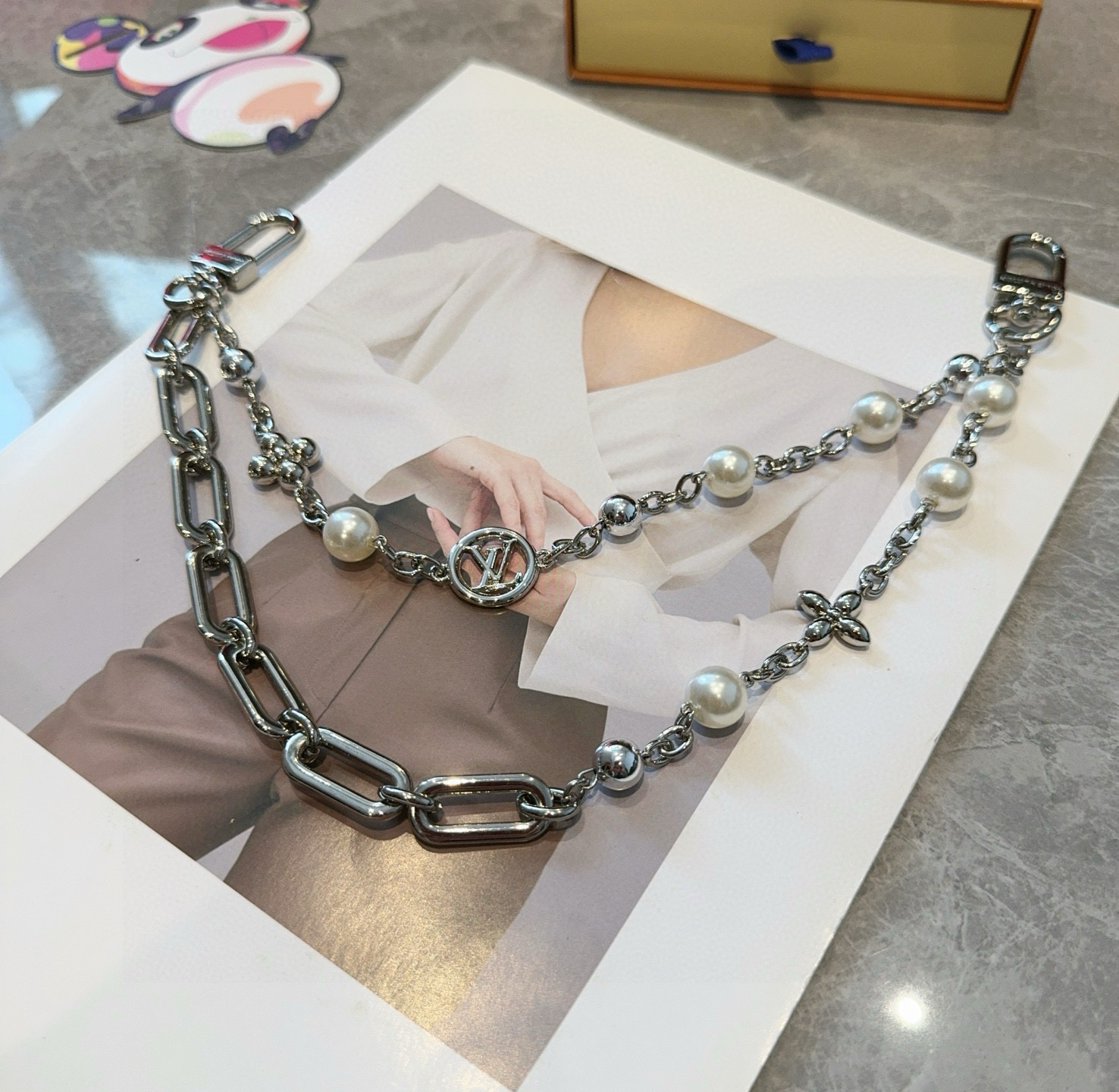 
P100🔥LV钥匙扣 包包挂链 Figaro 腰带链以莹泽黄铜锻造双链设计，再令品牌经典标识巧妙嵌入链环之间。LV字母装饰于一端优雅垂坠，弹簧扣实现轻松固定，为裤装或手袋注入潮流锋芒。