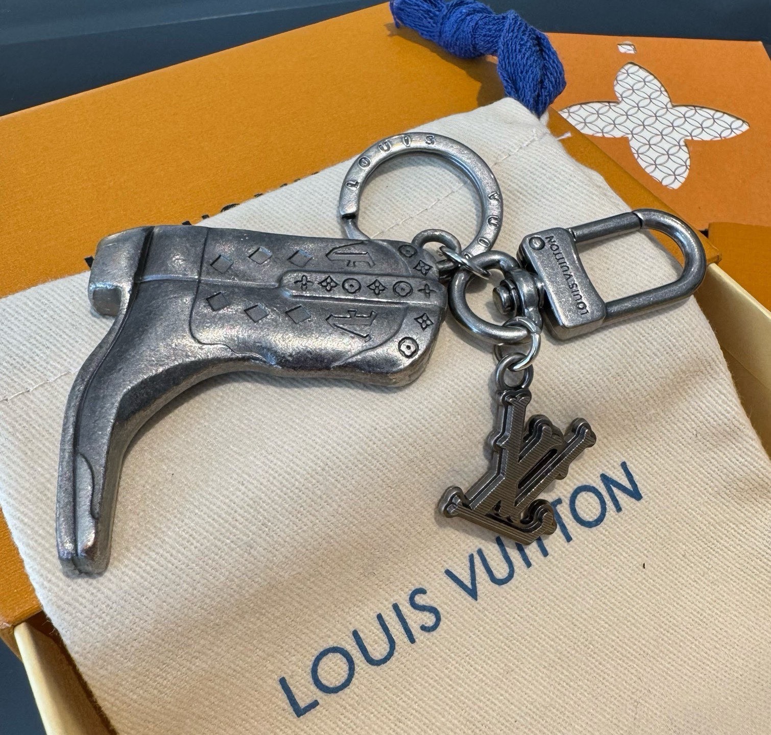 LV钥匙扣 靴子挂件车钥匙挂饰，品牌经典标识巧妙嵌入链环之间。LV字母装饰于一端优雅垂坠，弹簧扣实现轻松