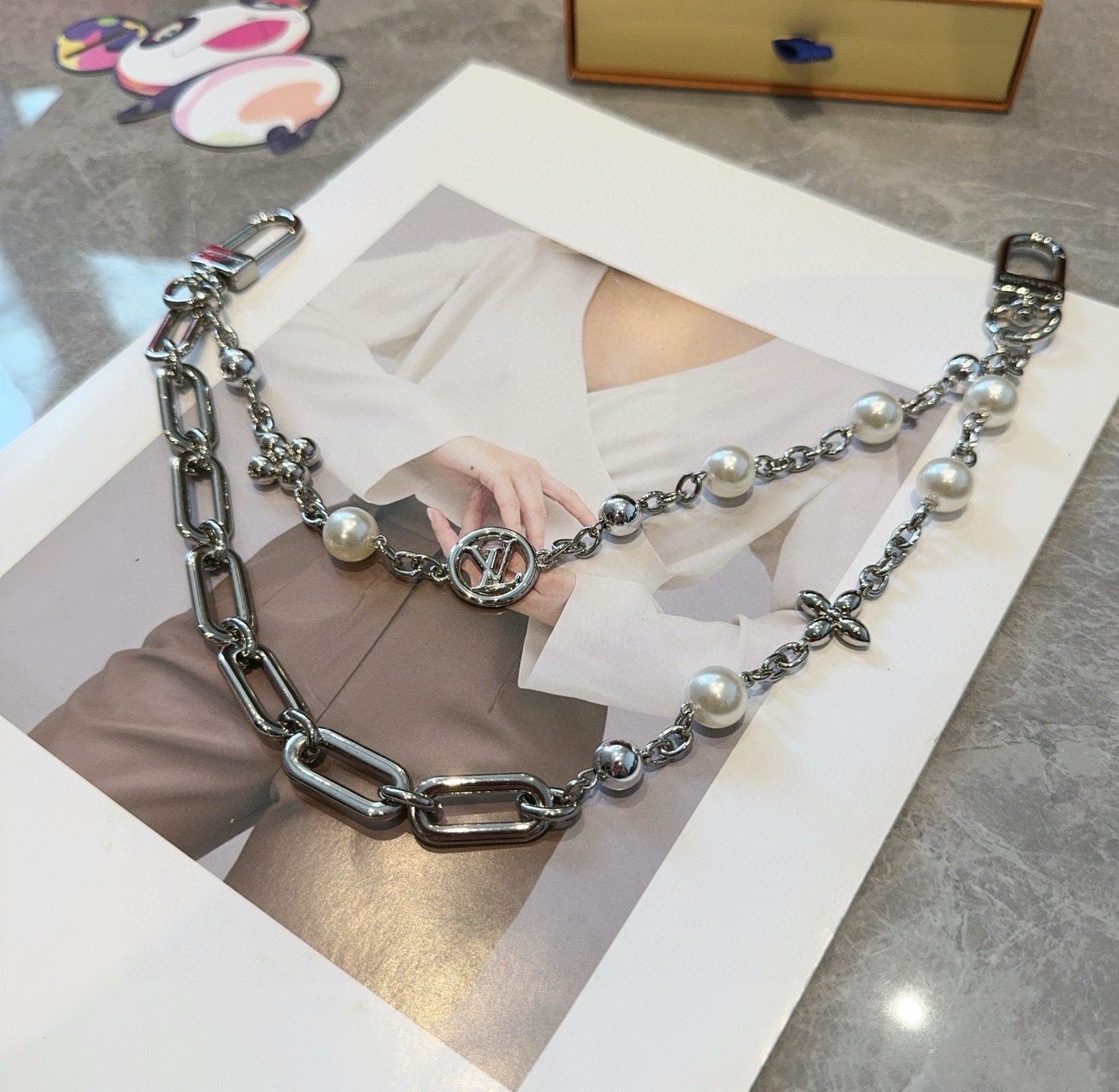 LV钥匙扣 包包挂链 Figaro 腰带链以莹泽黄铜锻造双链设计，再令品牌经典标识巧妙嵌入链环之间。LV