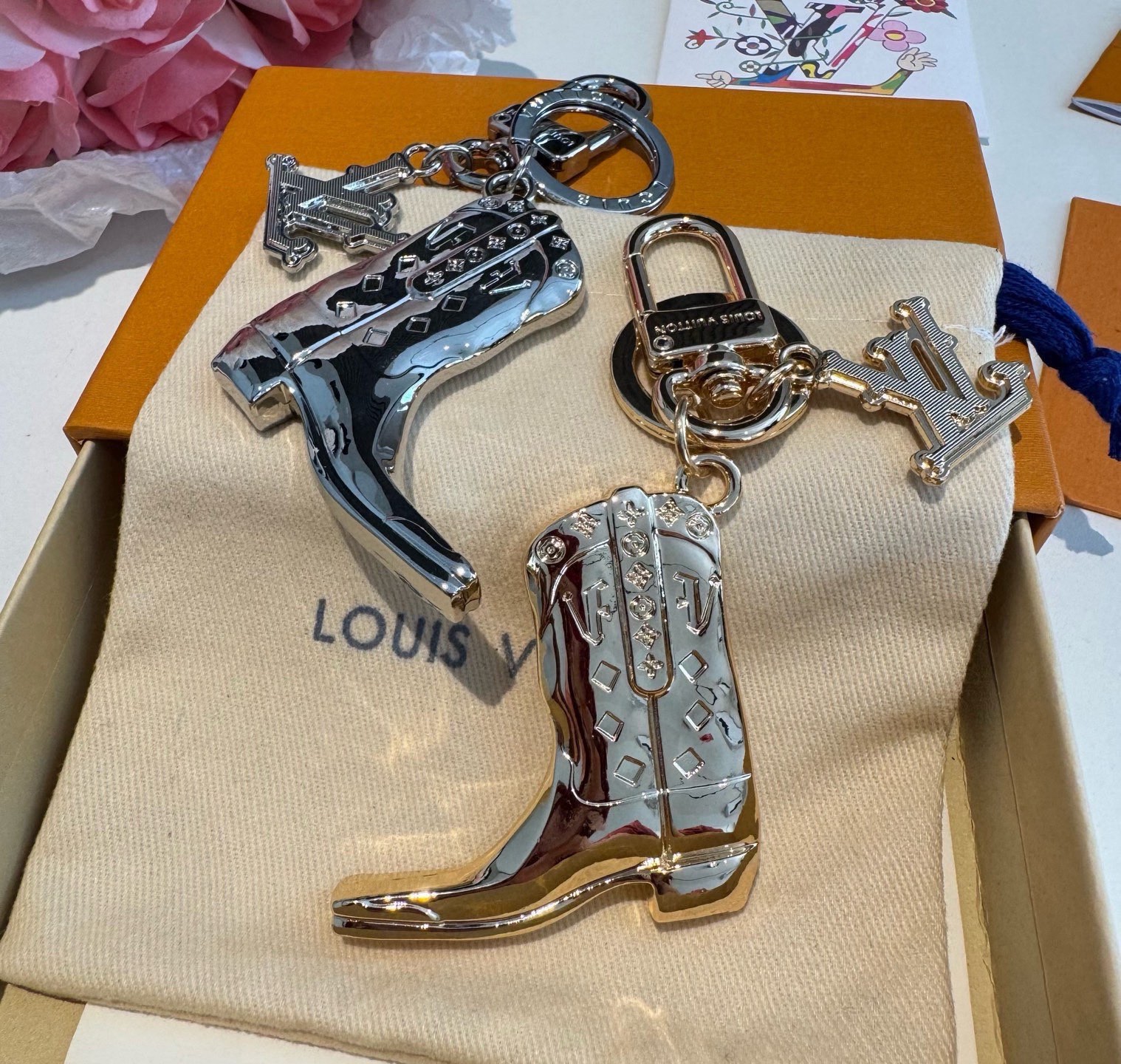 LV钥匙扣 靴子挂件车钥匙挂饰，品牌经典标识巧妙嵌入链环之间。LV字母装饰于一端优雅垂坠，弹簧扣实现轻松