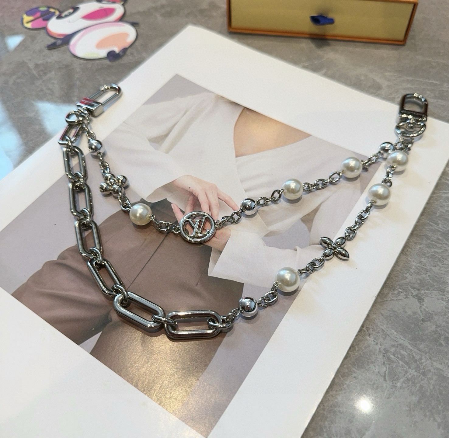 LV钥匙扣 包包挂链 Figaro 腰带链以莹泽黄铜锻造双链设计，再令品牌经典标识巧妙嵌入链环之间。LV
