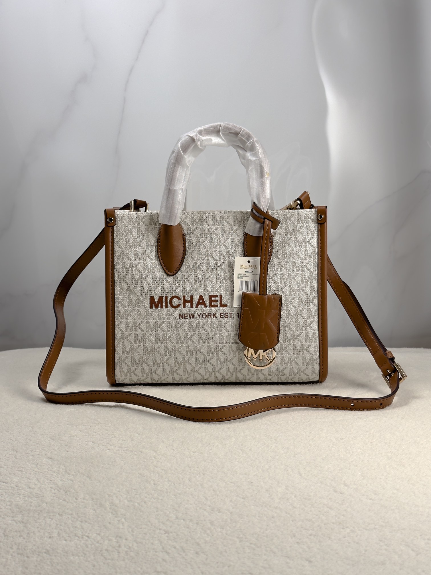 Michael Kors 印花打造包身，上缀 Michael Kors 字母印花装饰，皮革