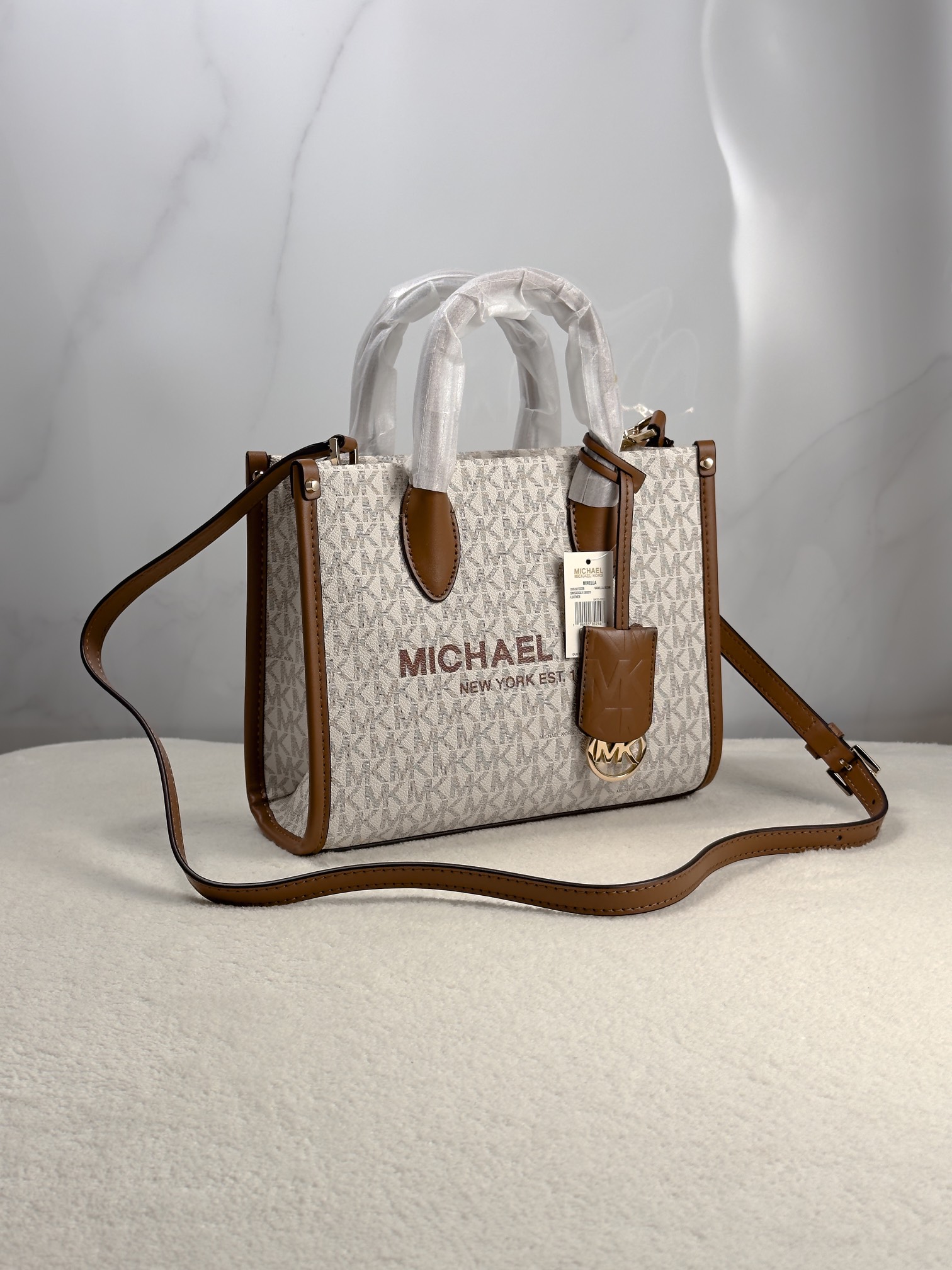 Michael Kors 印花打造包身，上缀 Michael Kors 字母印花装饰，皮革