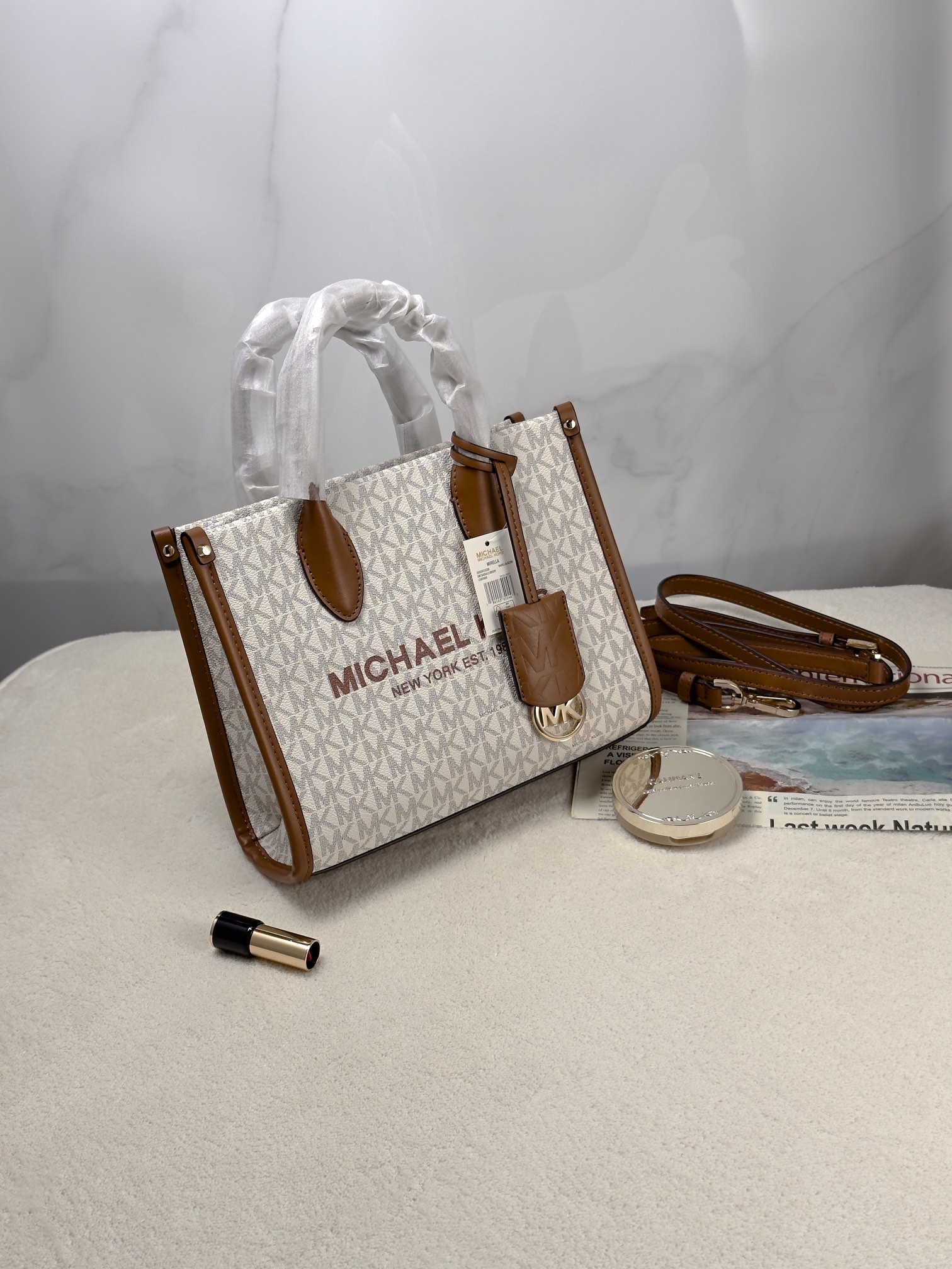 Michael Kors 印花打造包身，上缀 Michael Kors 字母印花装饰，皮革
