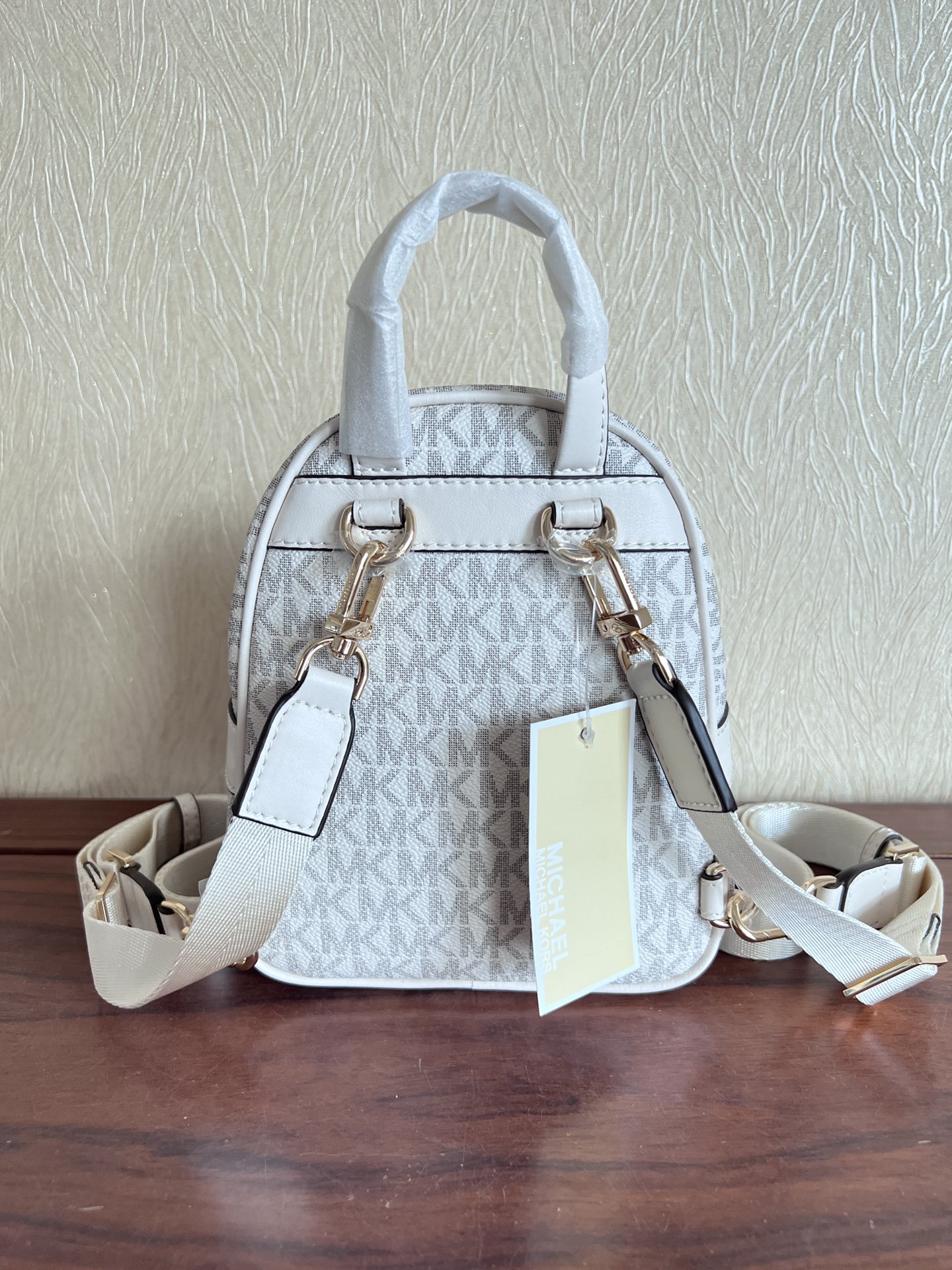 Michael Kors ～此款Elliot 超小号老花双肩包 采用香草白色品牌标志性 Logo印花材质打造小巧包身