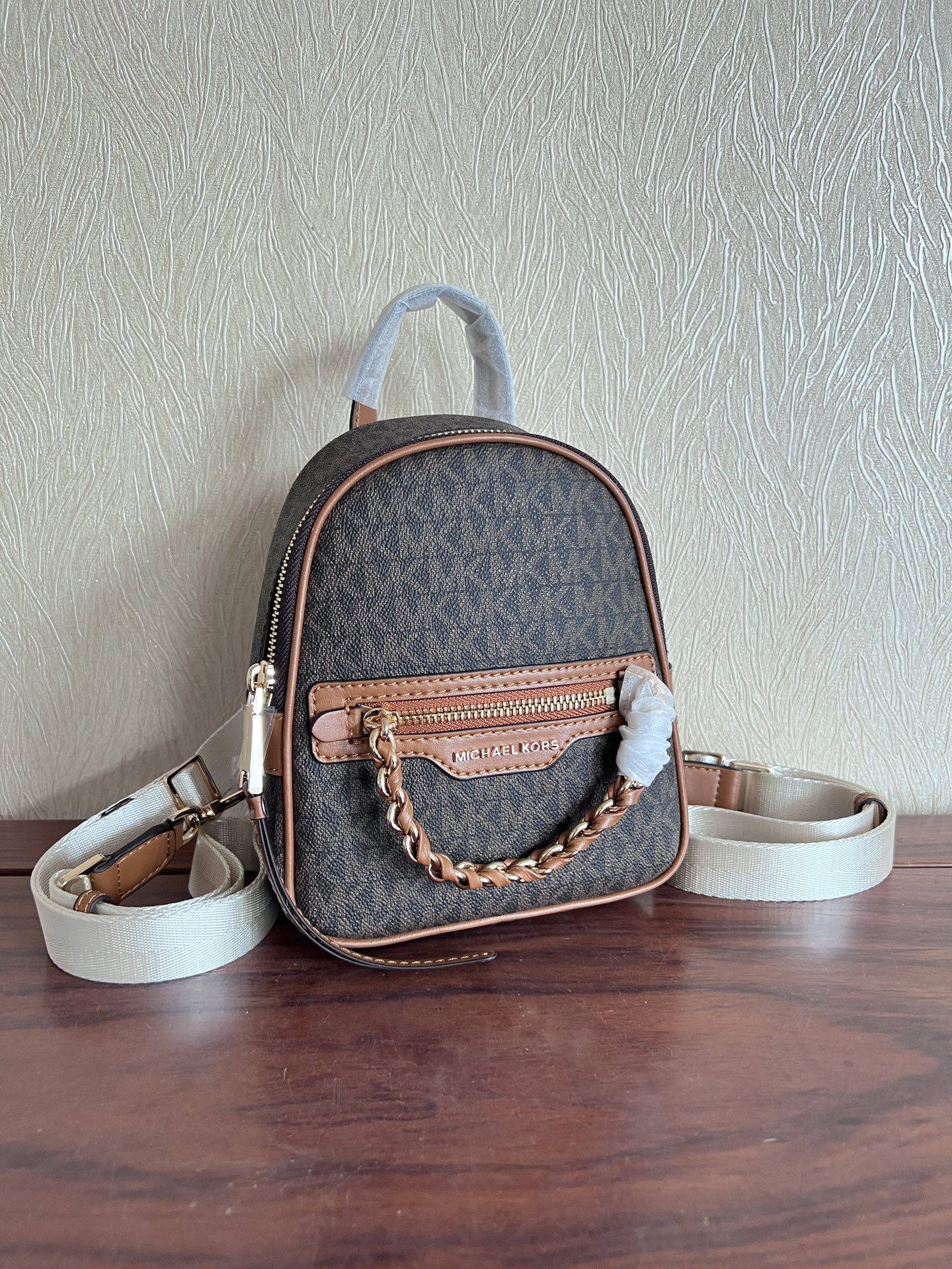 Michael Kors ～此款Elliot 超小号老花双肩包 采用香草白色品牌标志性 Logo印花材质打造小巧包身
