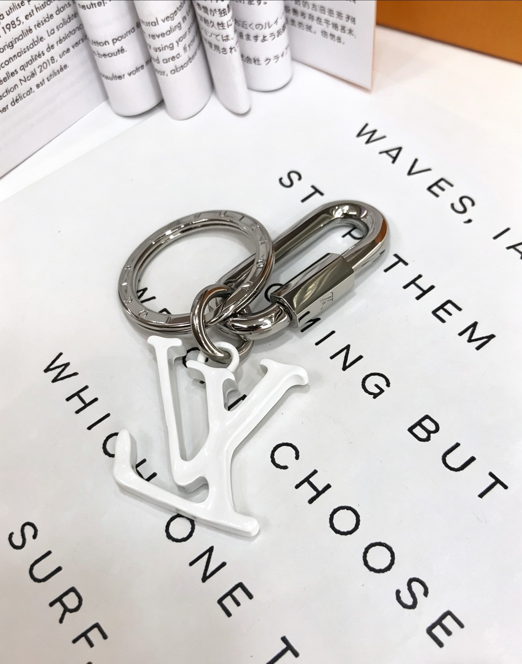 Louis Vuitton 本季腰带上的醒目搭扣化身为 1V Shape 包饰与钥匙扣 是一款标新立异的品牌标识