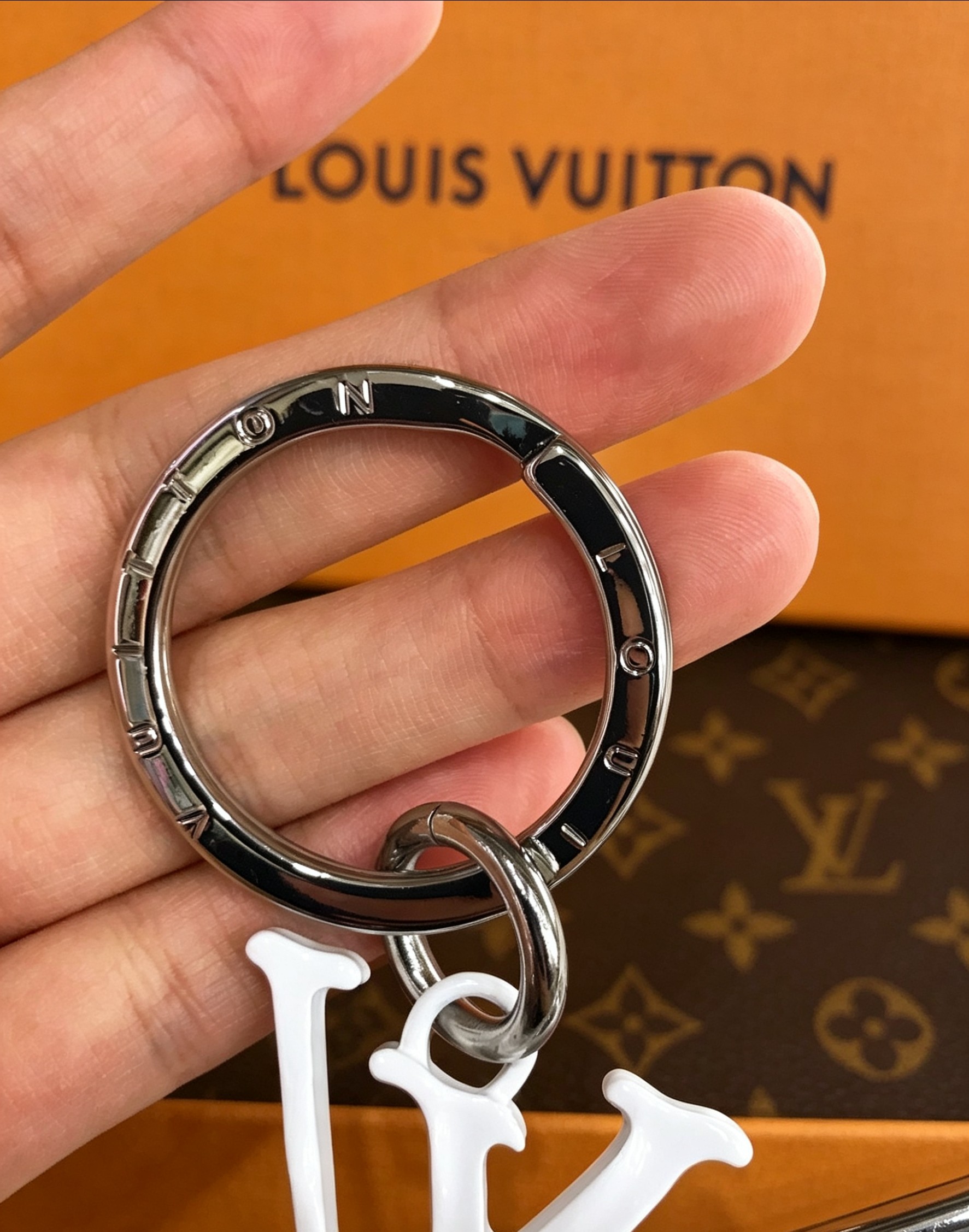 Louis Vuitton 本季腰带上的醒目搭扣化身为 1V Shape 包饰与钥匙扣 是一款标新立异的品牌标识